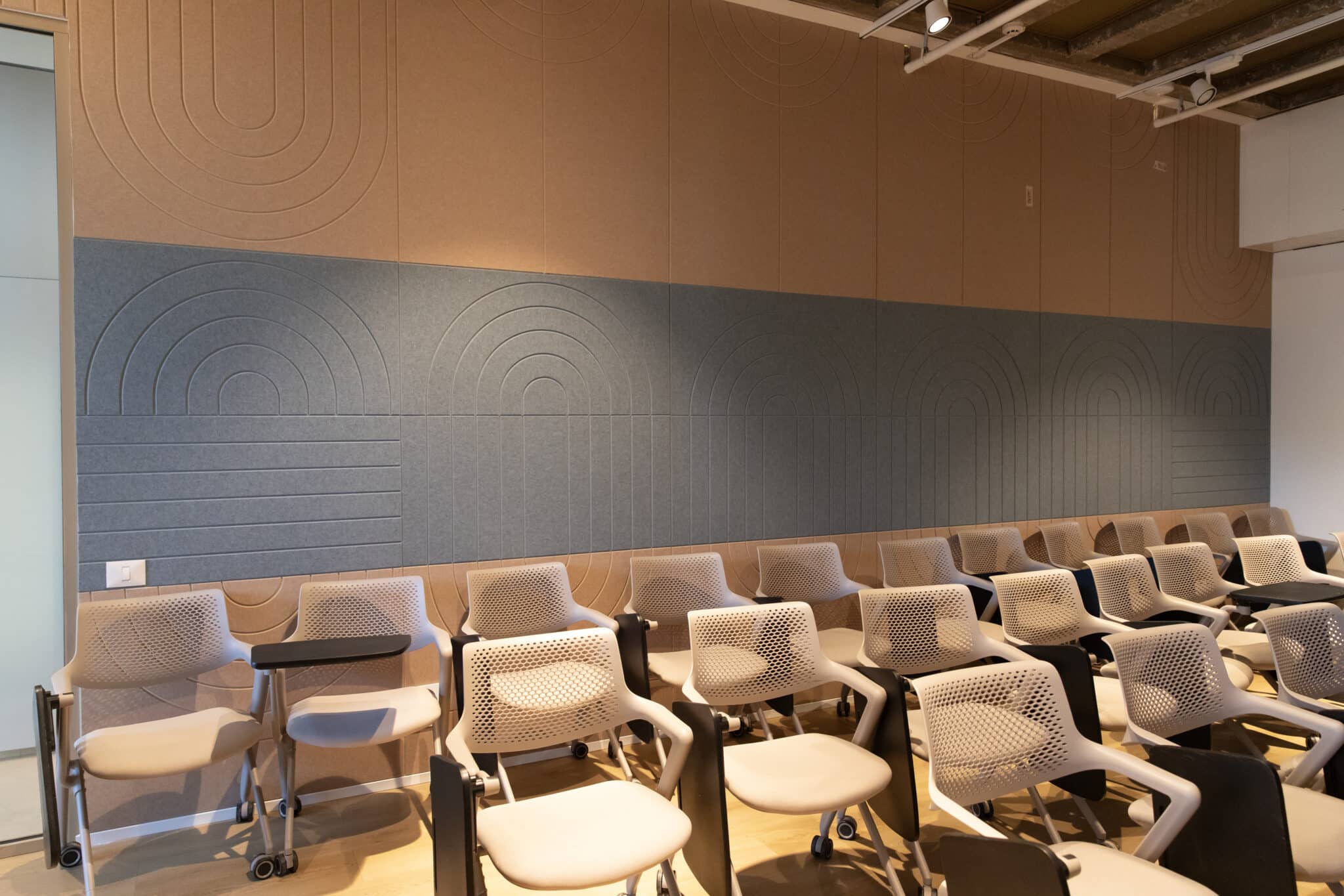Acoustic panels with routed arc lines in a lecture room