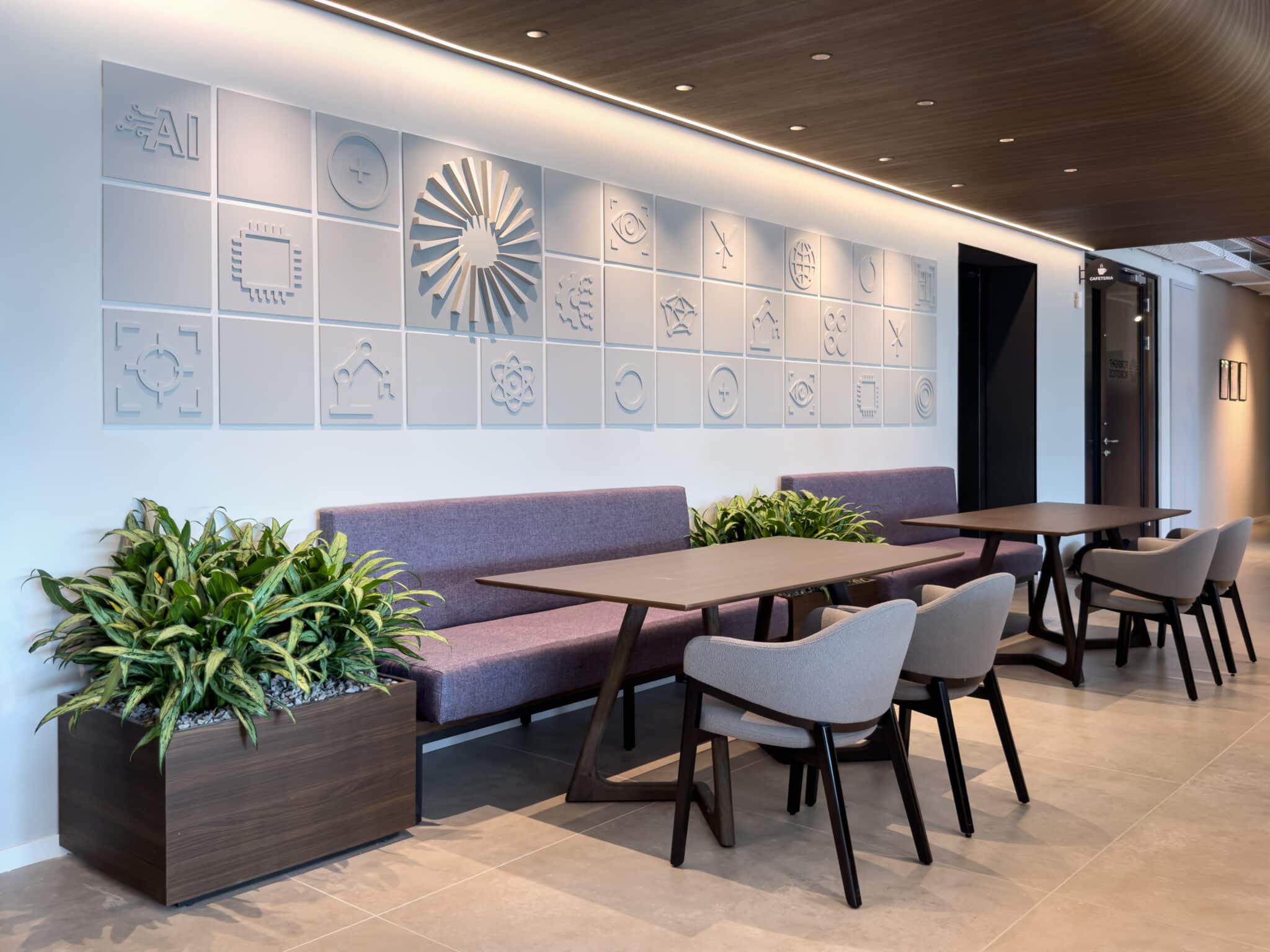 Relief pictogram tile wall above dining benches