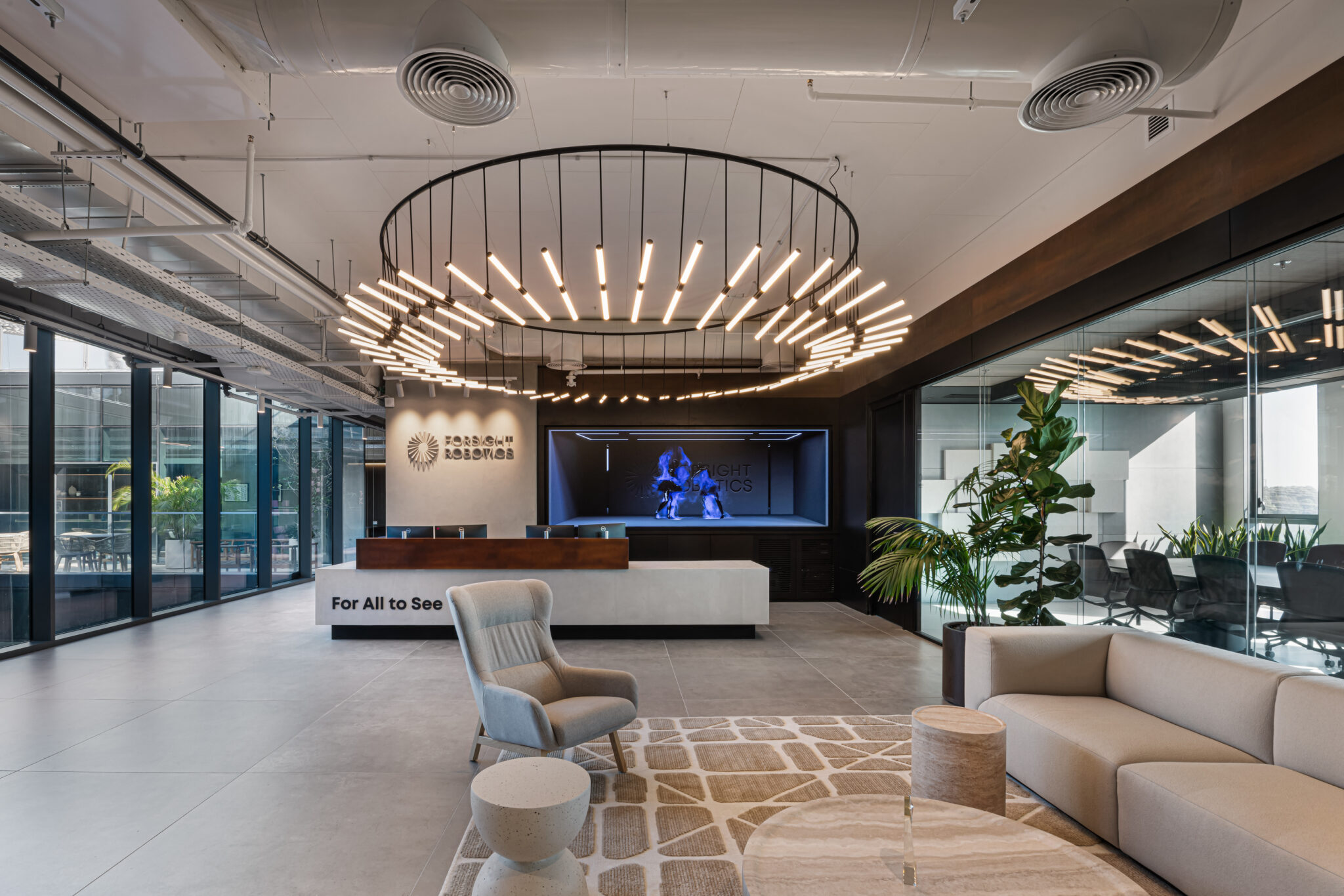 Reception lobby with a logo wall and a large ring light