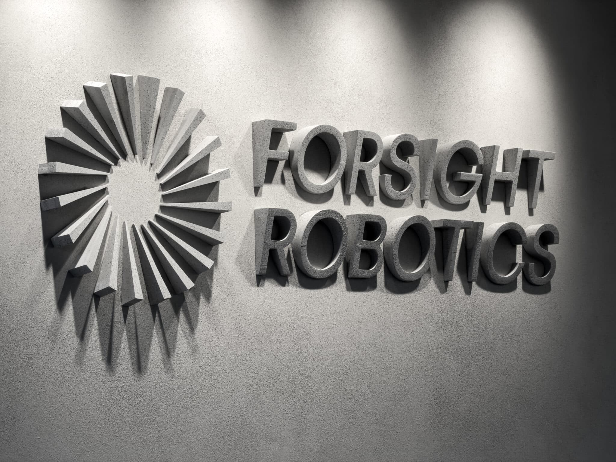 Concrete grey 3D logo and letters lit on a wall