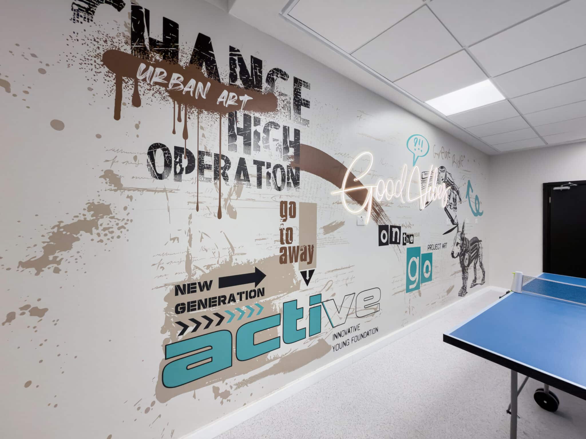 Graffiti lettering wall graphic beside a ping pong table