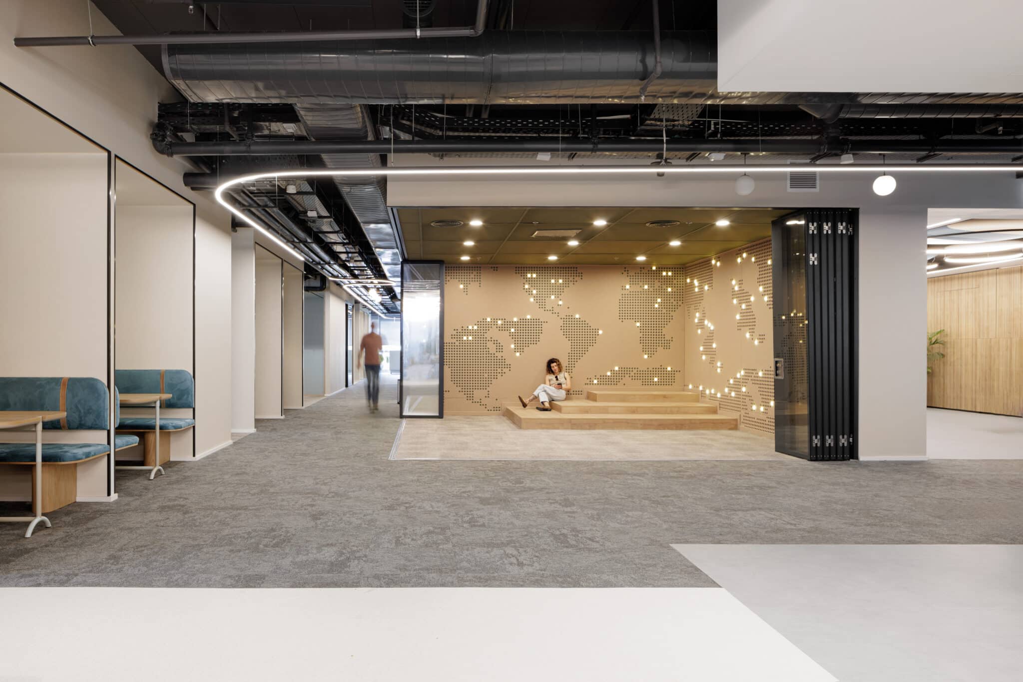 Perforated world map wall with lit points above a seating step