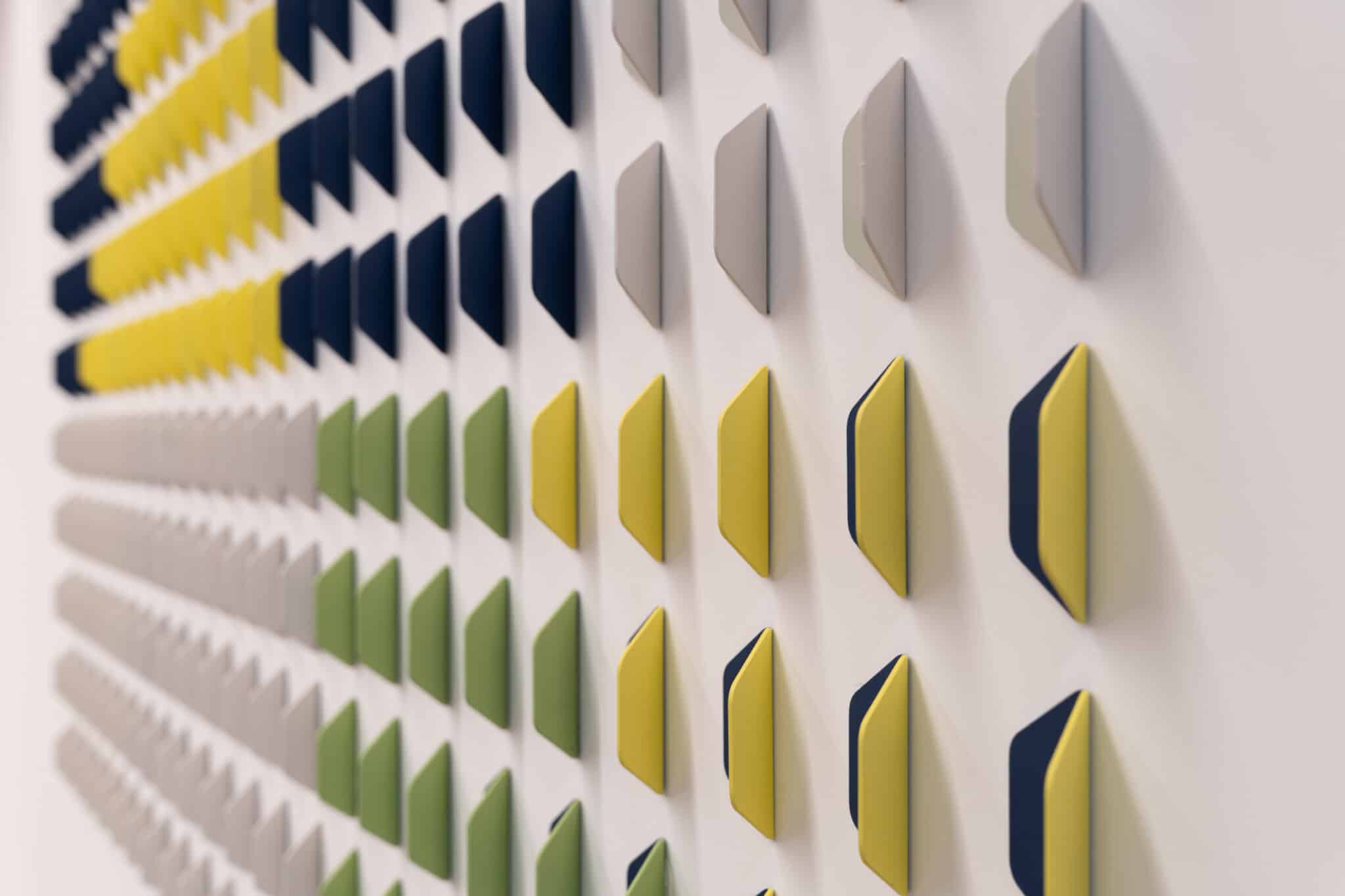 Wall of raised coloured tiles graded from blue to yellow