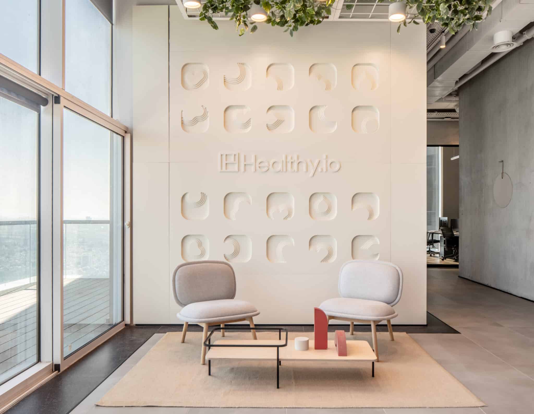 Healthy.io logo set into a relief wall of rounded recessed shapes