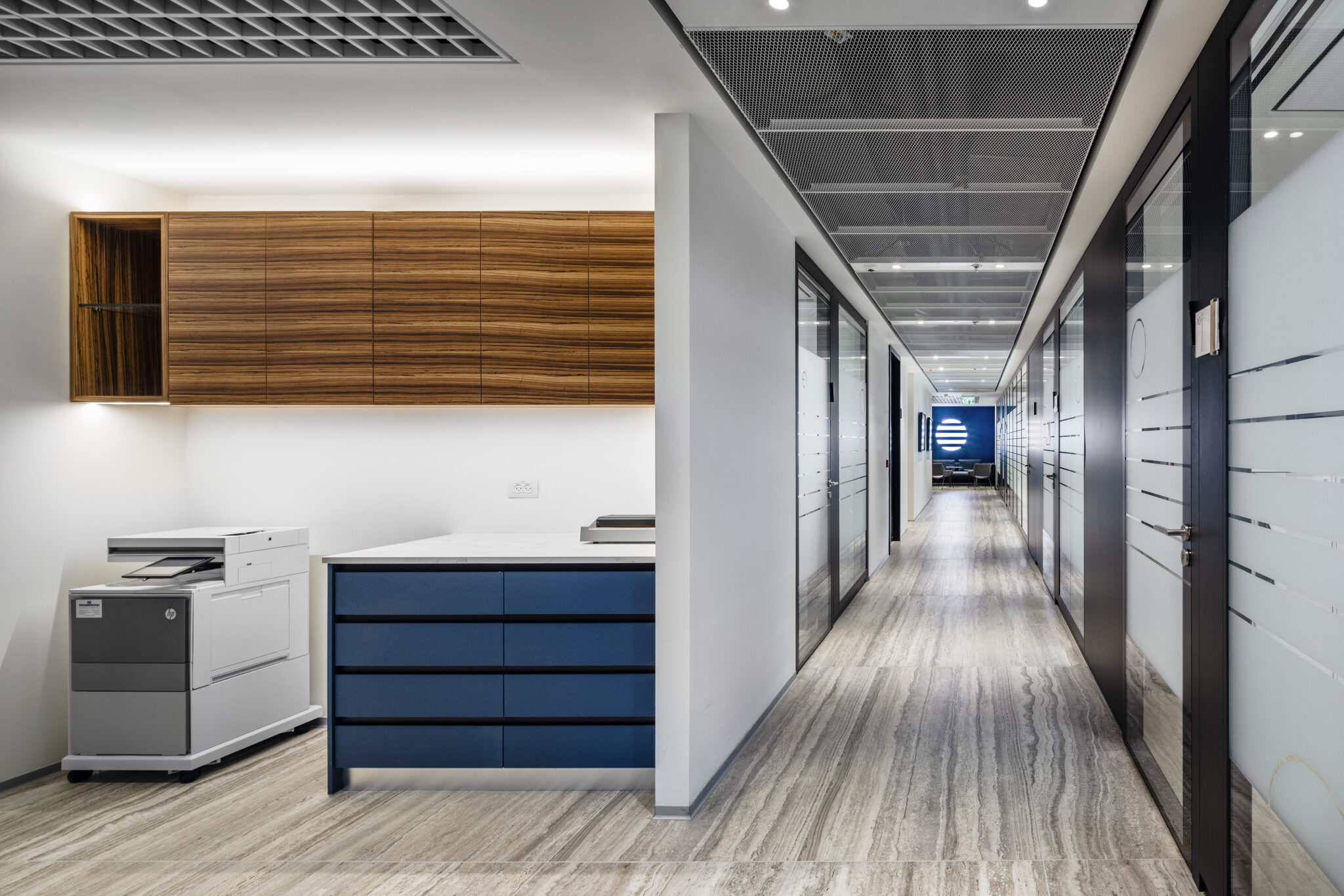 Line graphics on frosted glass along a corridor to a logo wall