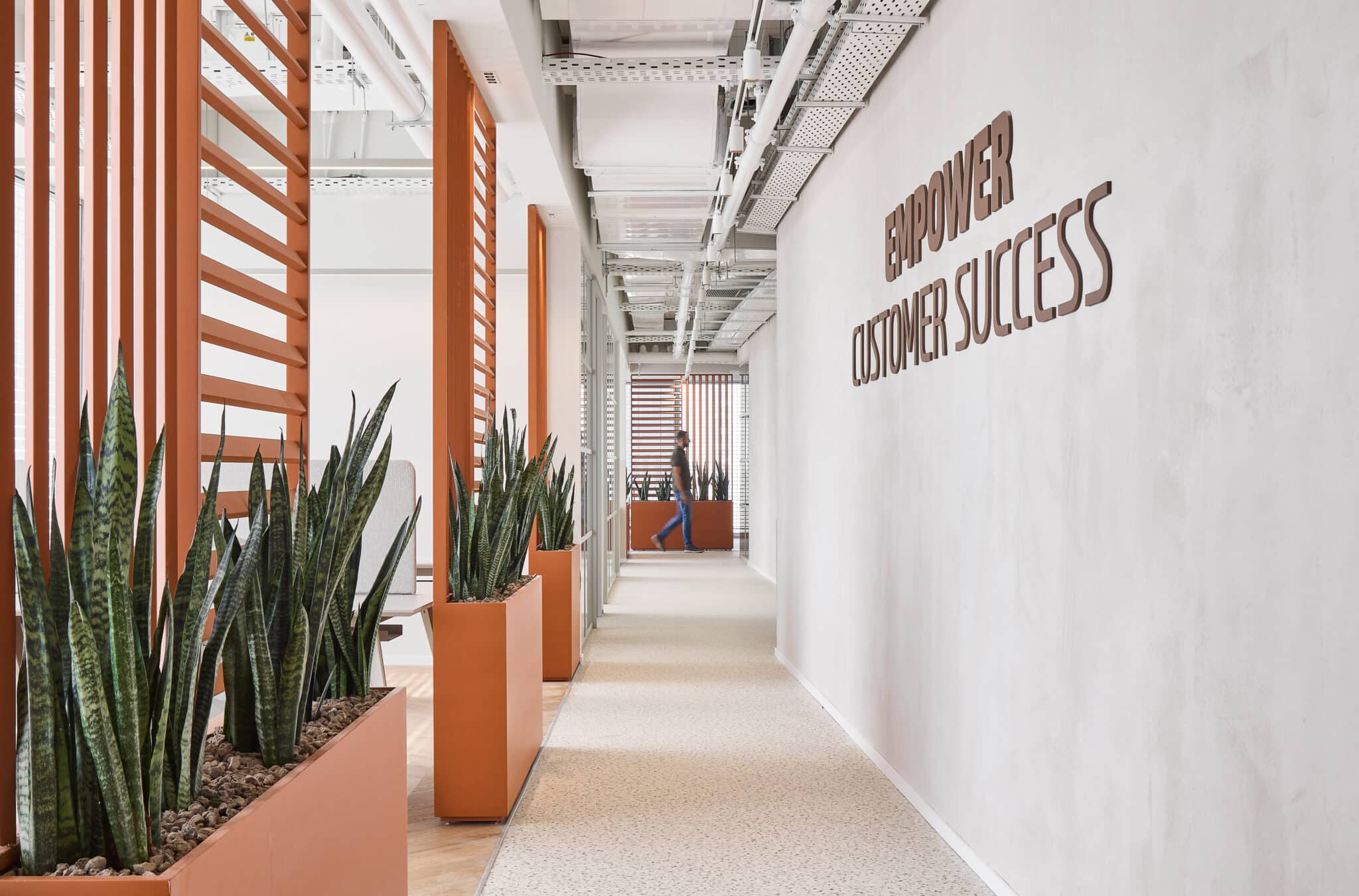 EMPOWER CUSTOMER SUCCESS 3D letters on a concrete corridor wall