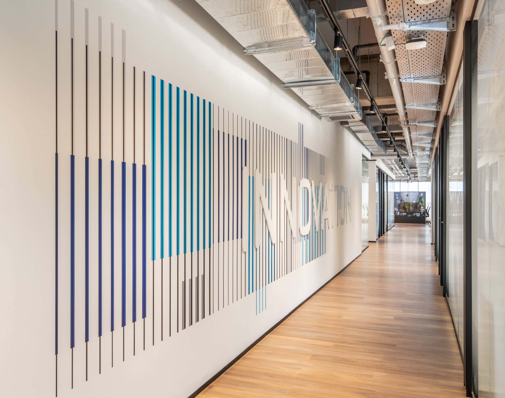 INNOVATION spelled out in a gradient of vertical stripes on the wall
