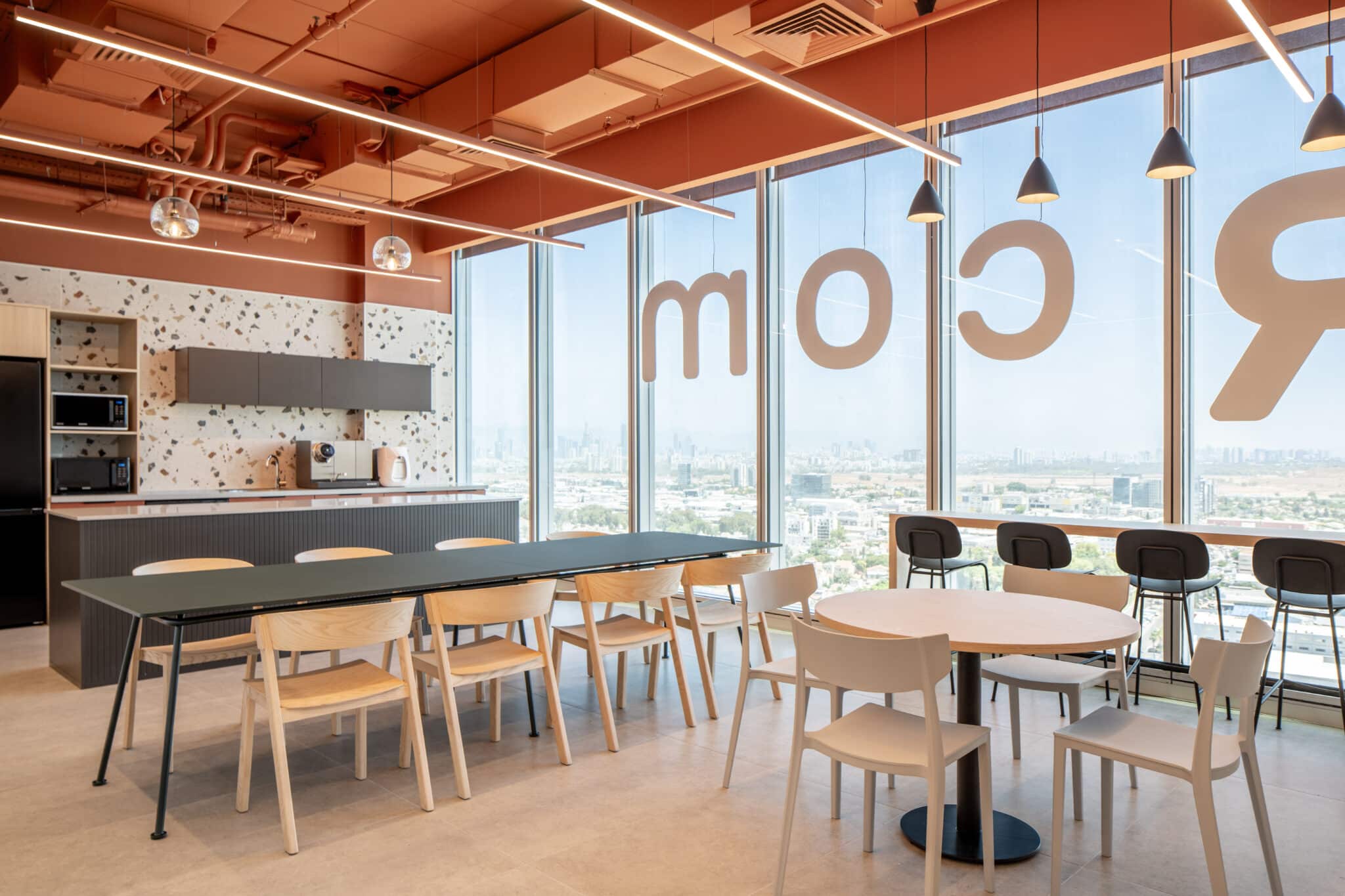 Orange window lettering across the office dining area glass