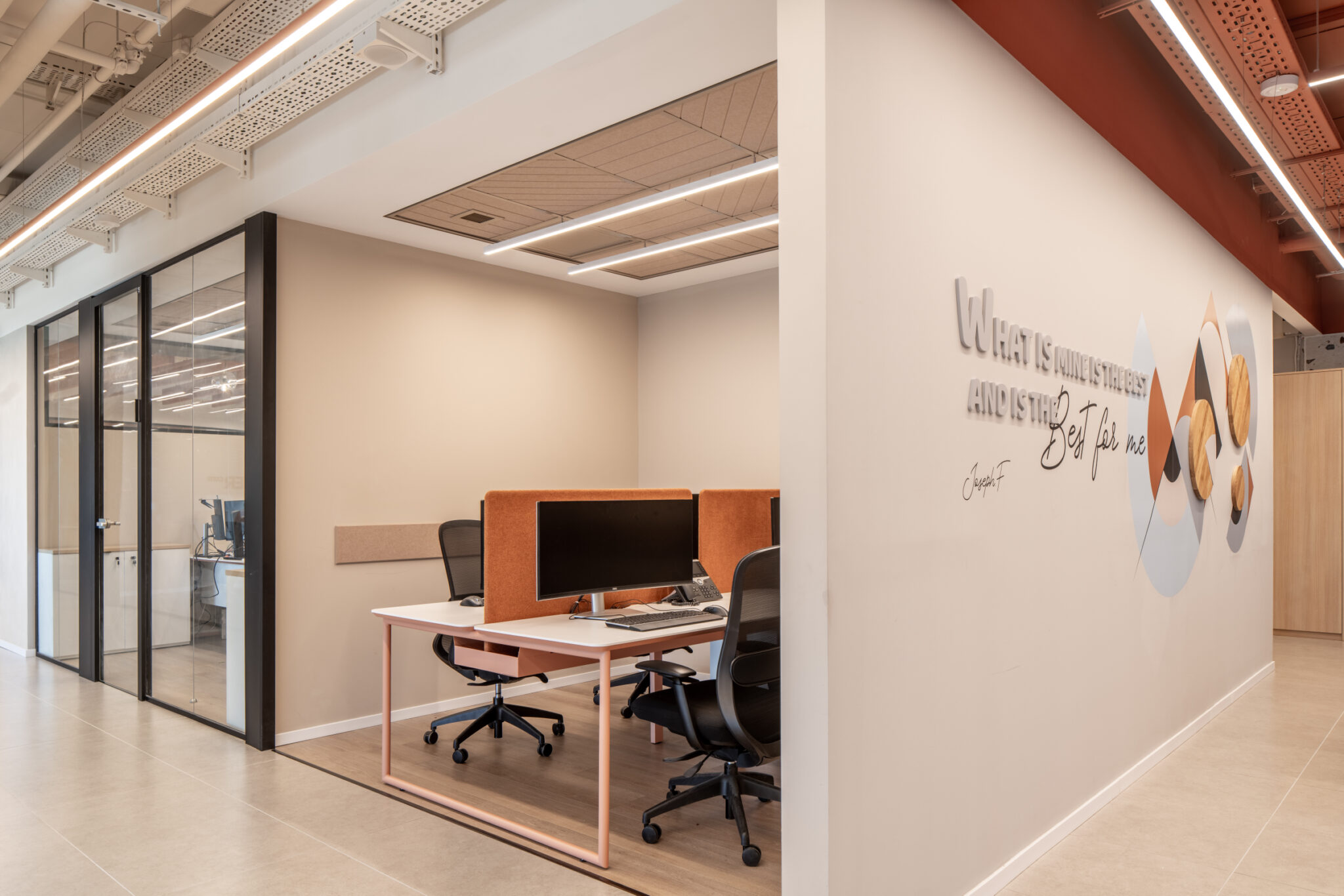 Quote lettering and circle graphics on a wall beside a glass office