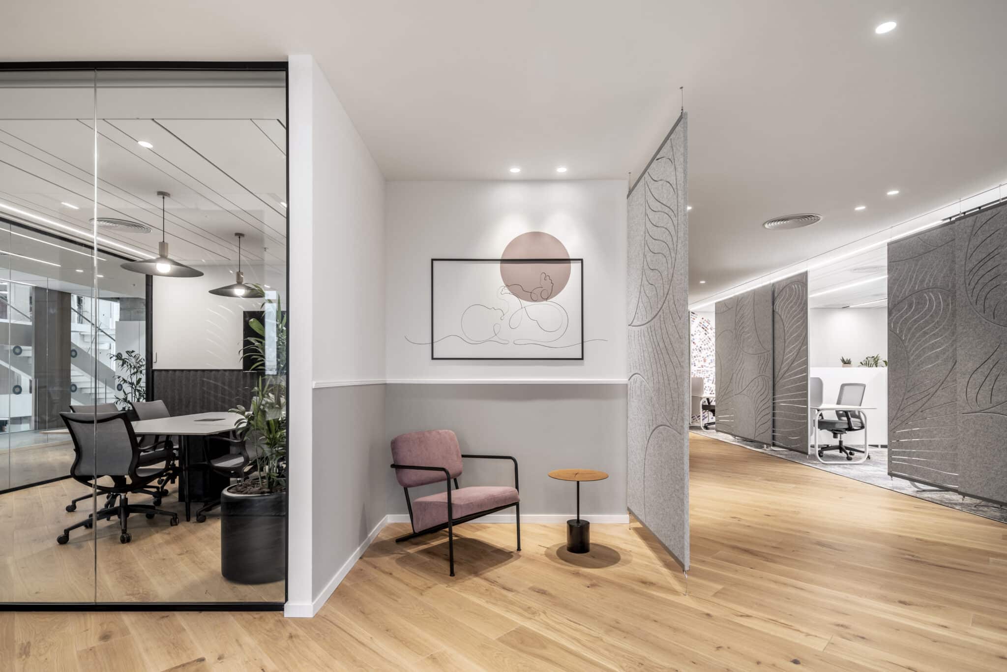 Framed artwork above a lounge chair beside carved acoustic felt panels