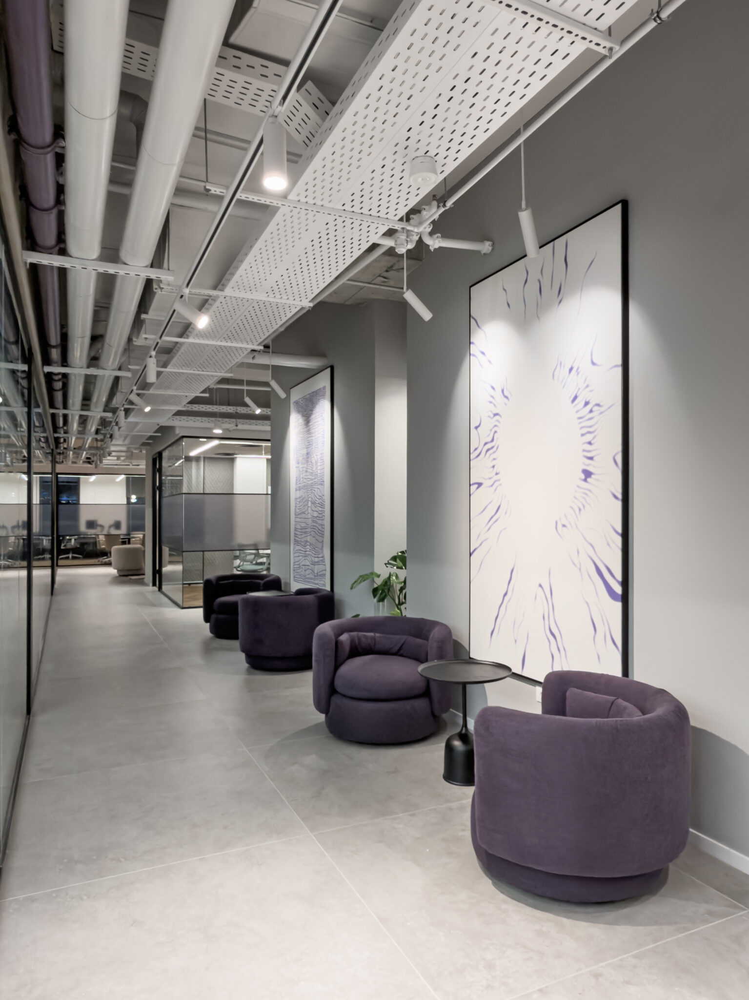 Large framed abstract artworks along a corridor seating area