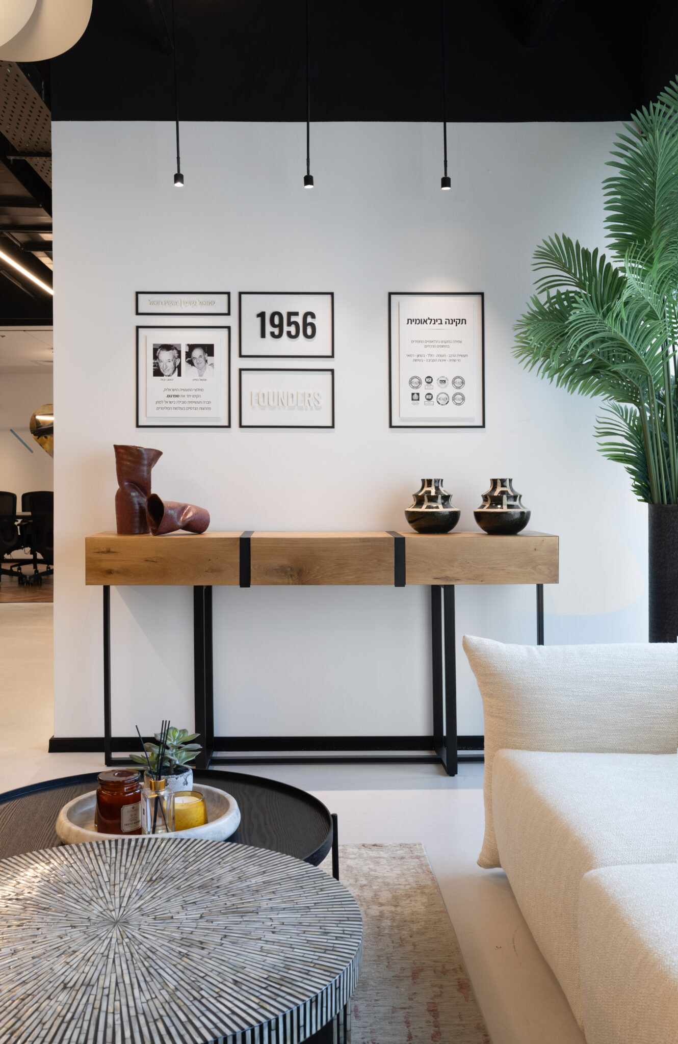Framed company history panels above a wood console table