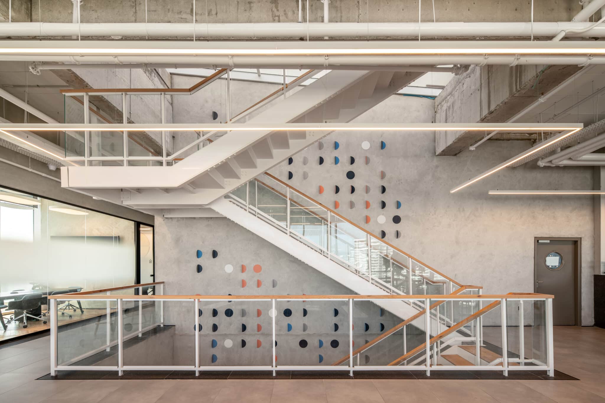 Coloured half-circle wall elements beside an open stairwell