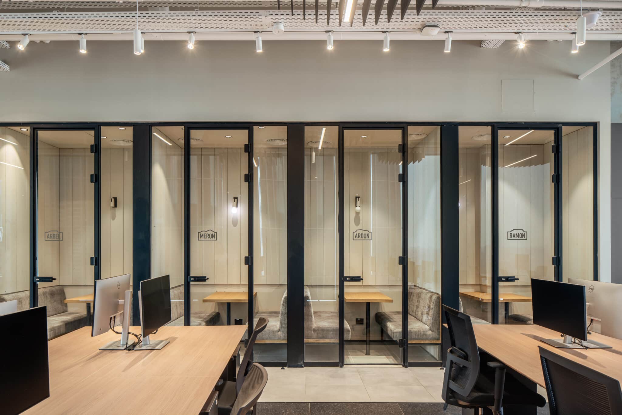 Phone booths with room name signs on the glass fronts
