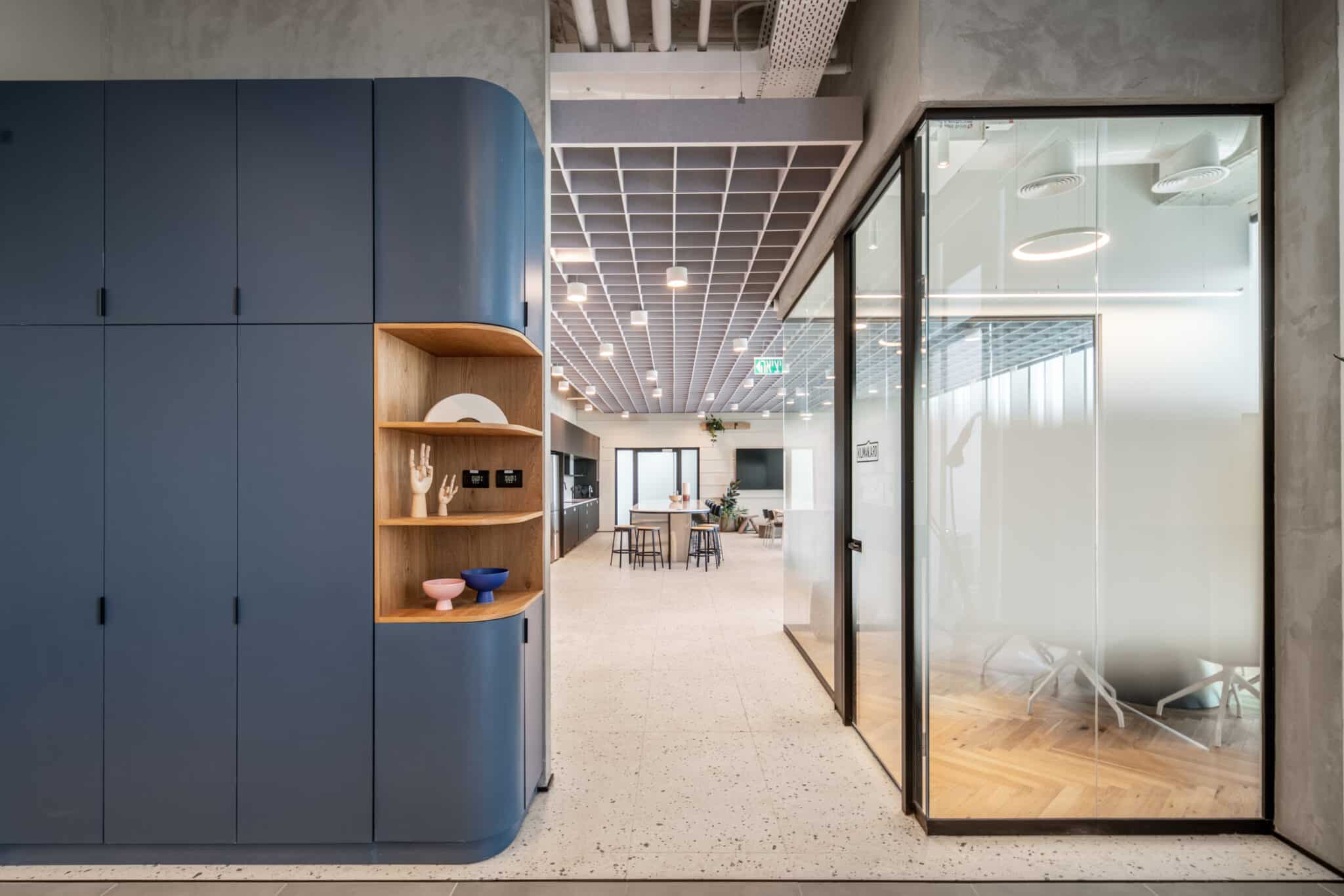 Frosted glass meeting room front beside blue storage joinery