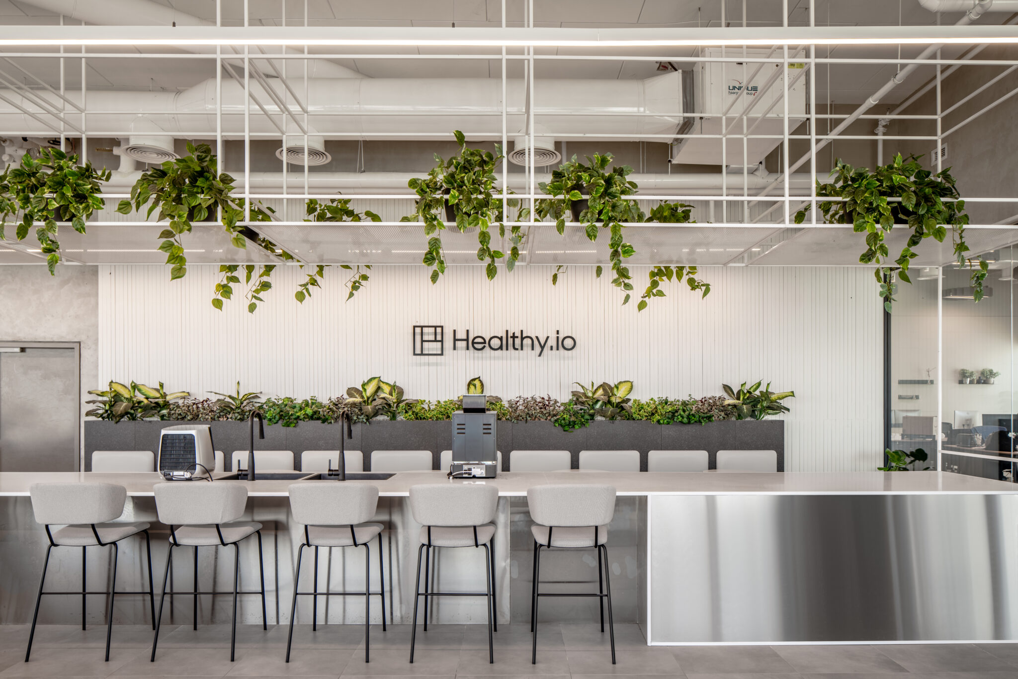 Healthy.io logo on a fluted wall above a planted counter