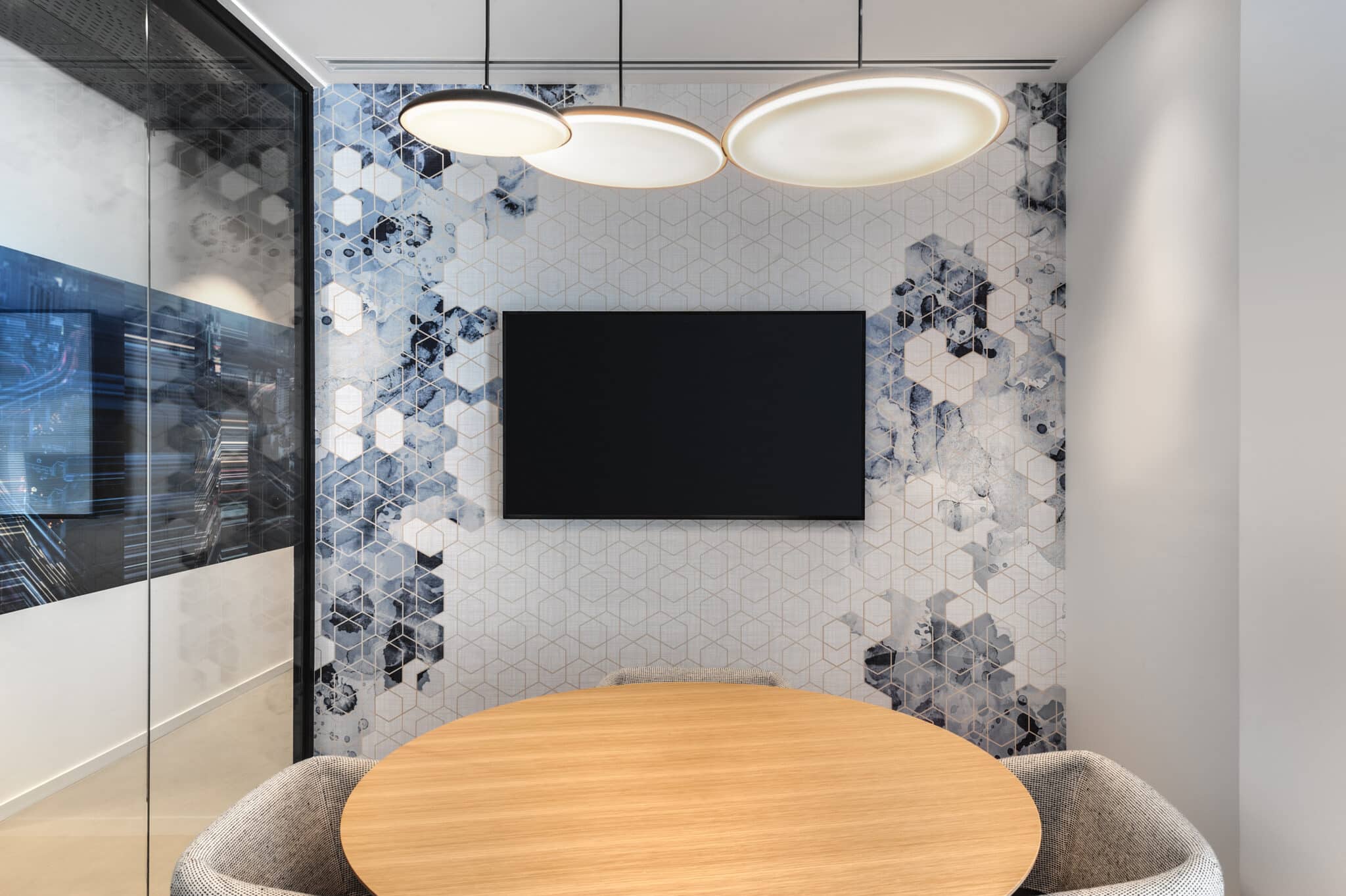 Hexagon pattern wall covering around a screen in a small meeting room