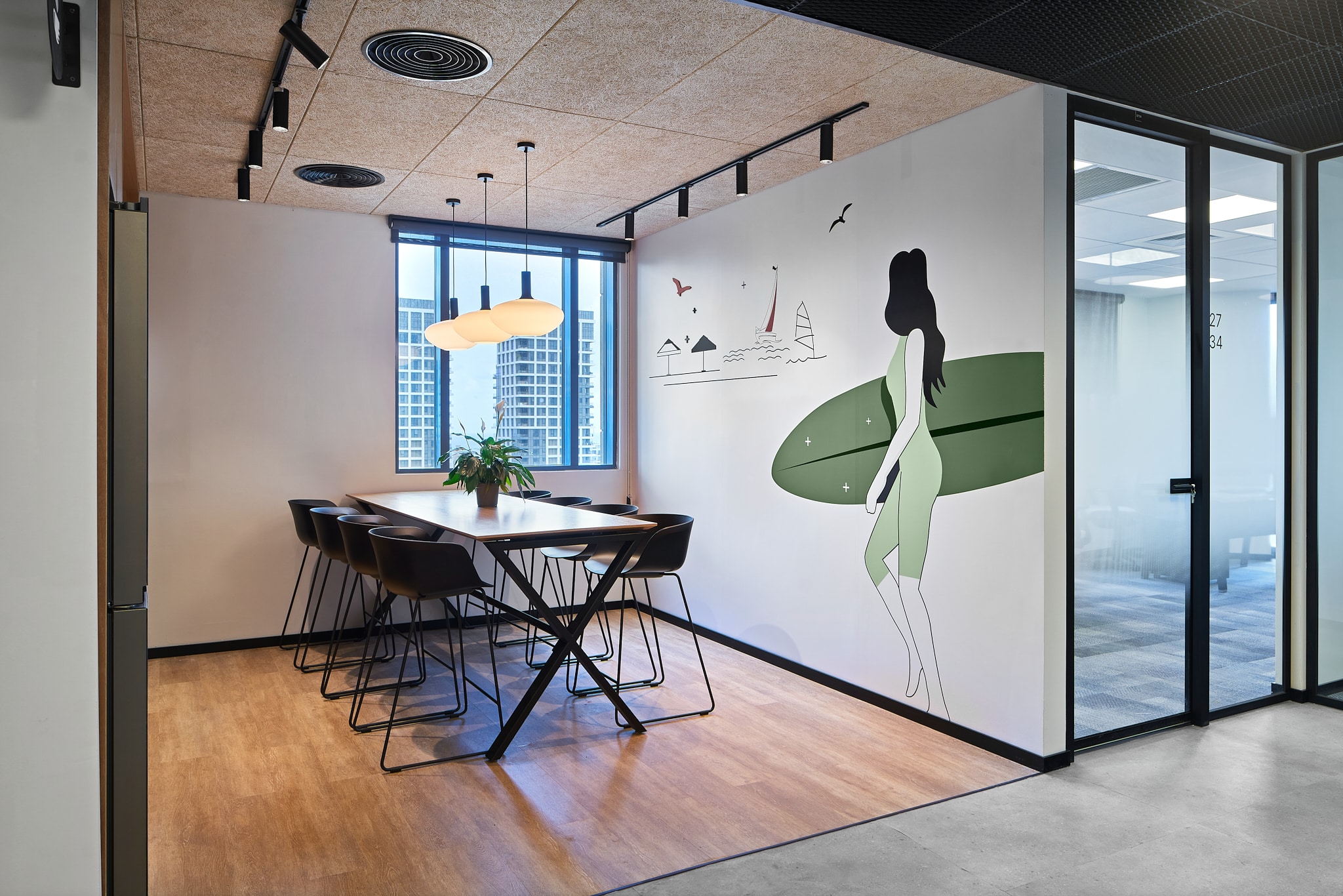Wall graphic of a surfer and a city skyline in a meeting room