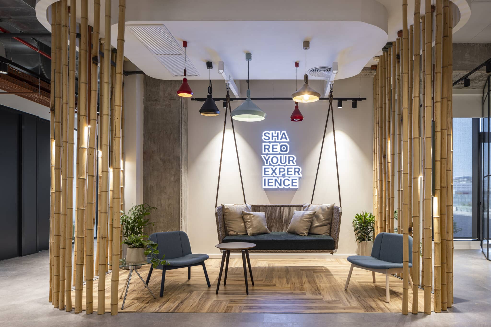 SHARE YOUR EXPERIENCE neon sign above a hanging bench