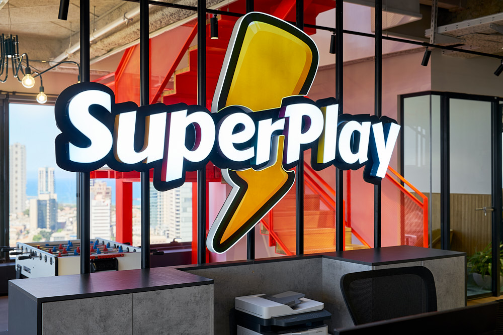 Illuminated 3D brand logo suspended above a reception area