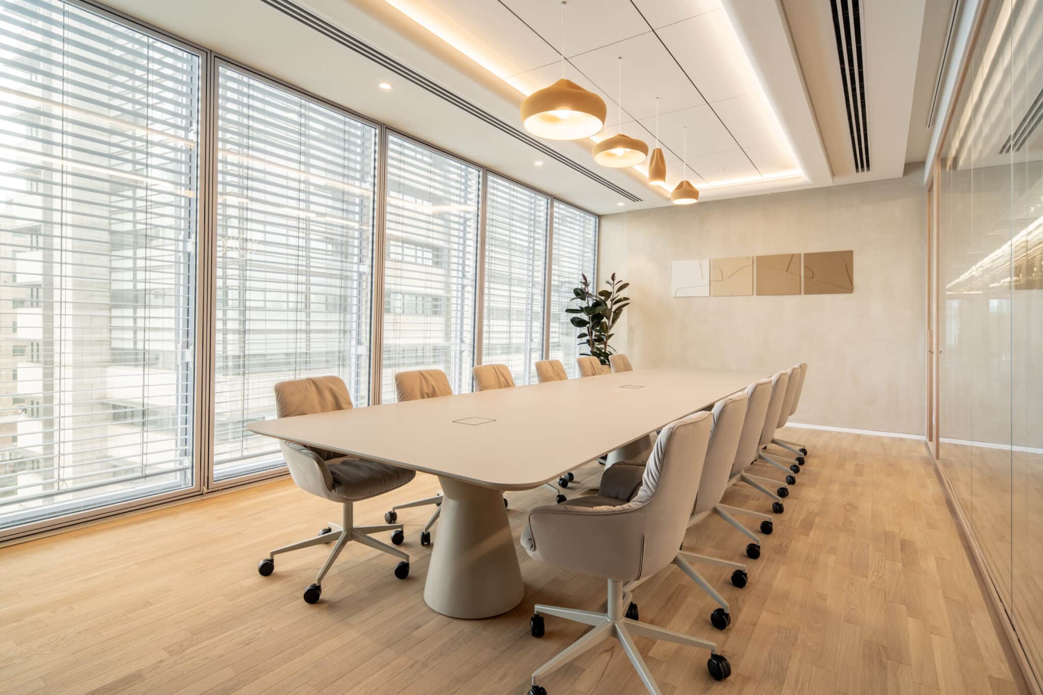 Four frames with layered graphics on a meeting room wall