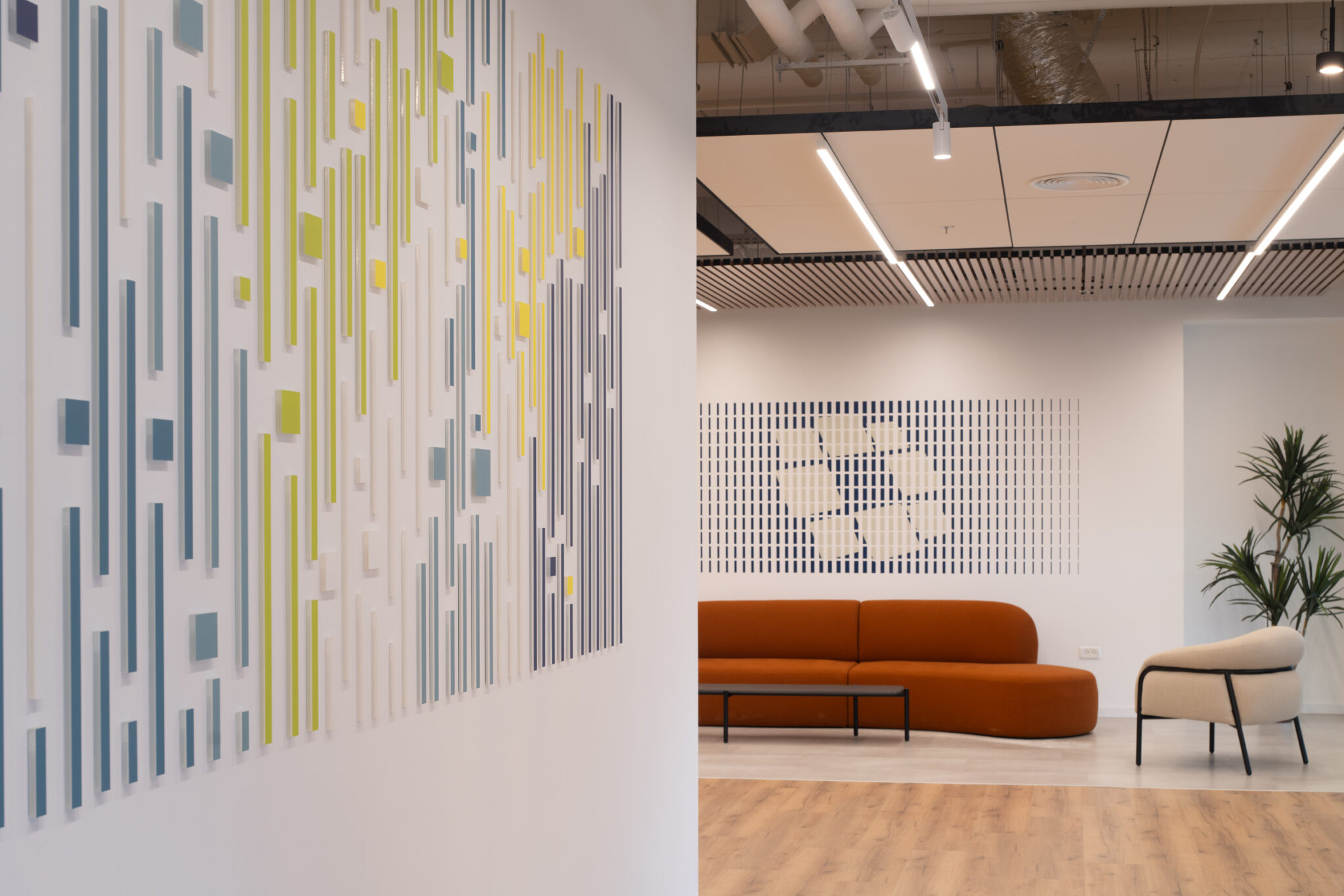 3D strip wall relief beside a framed grid artwork