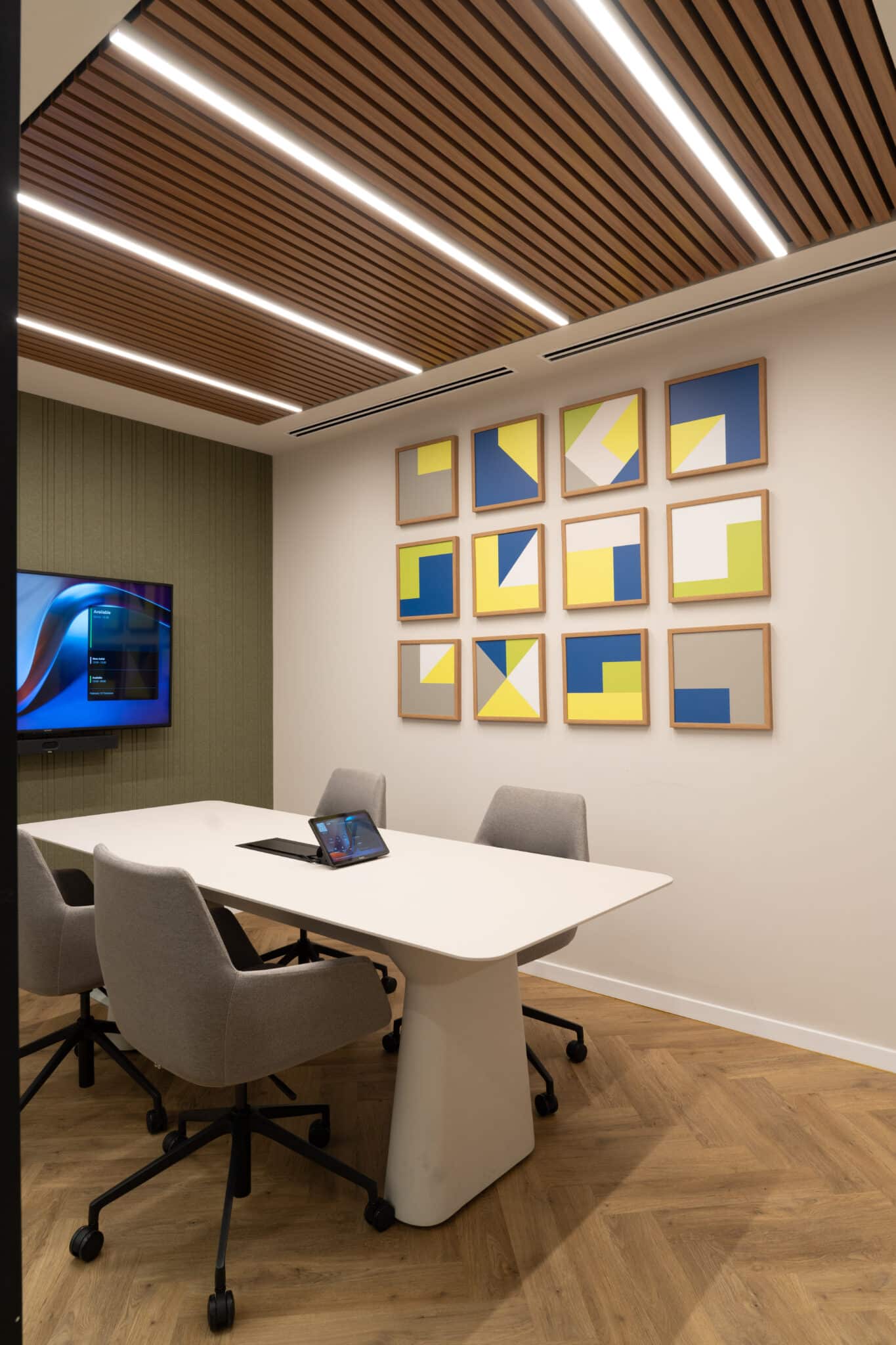 Nine framed geometric artworks on a meeting room wall