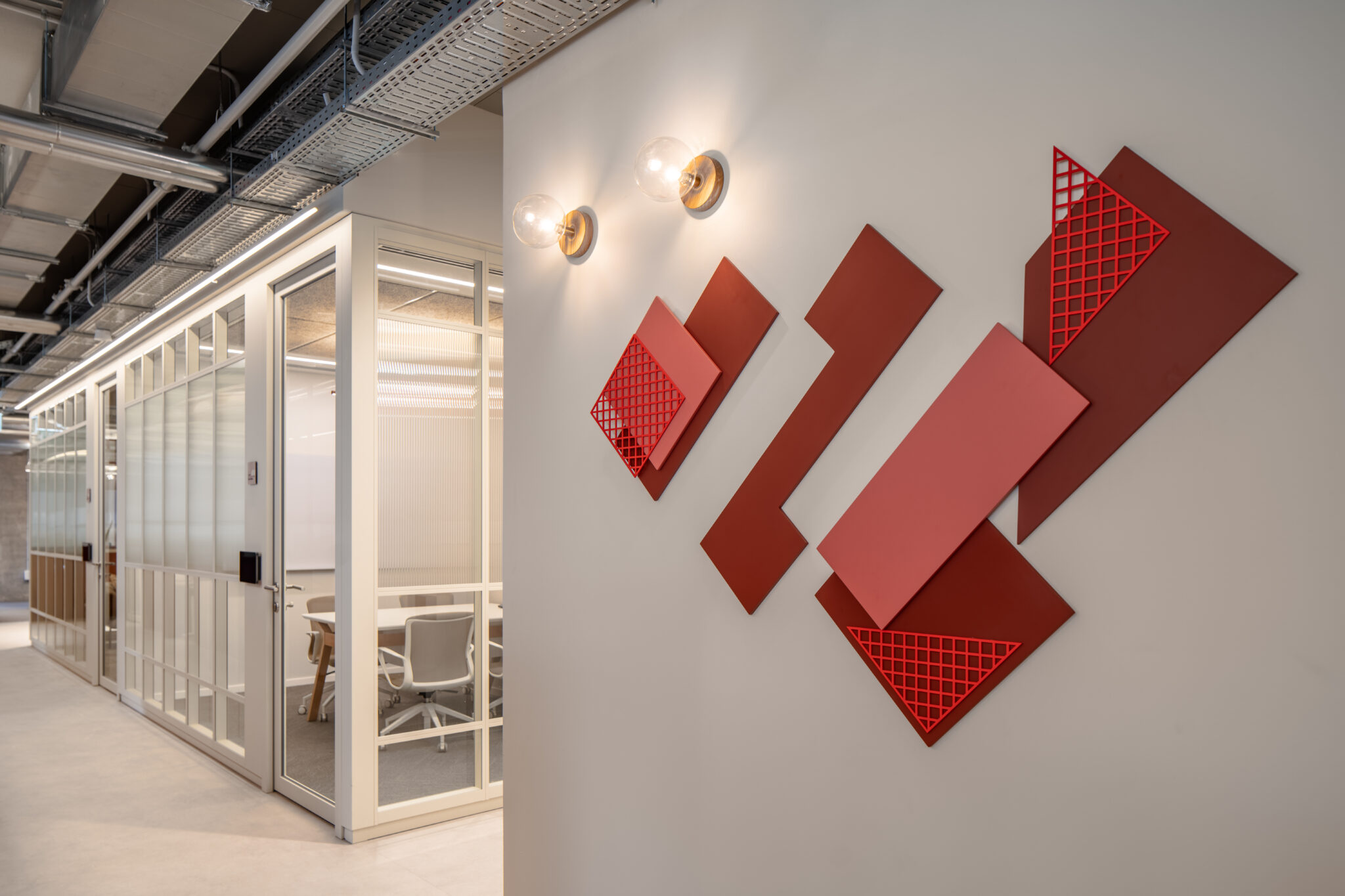 Red 3D geometric panels mounted on a corridor wall