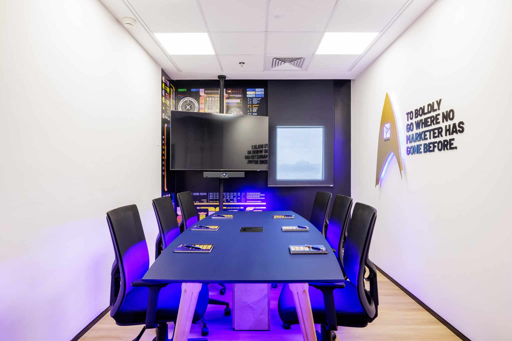 Quote wall graphic with a gold emblem in a themed meeting room