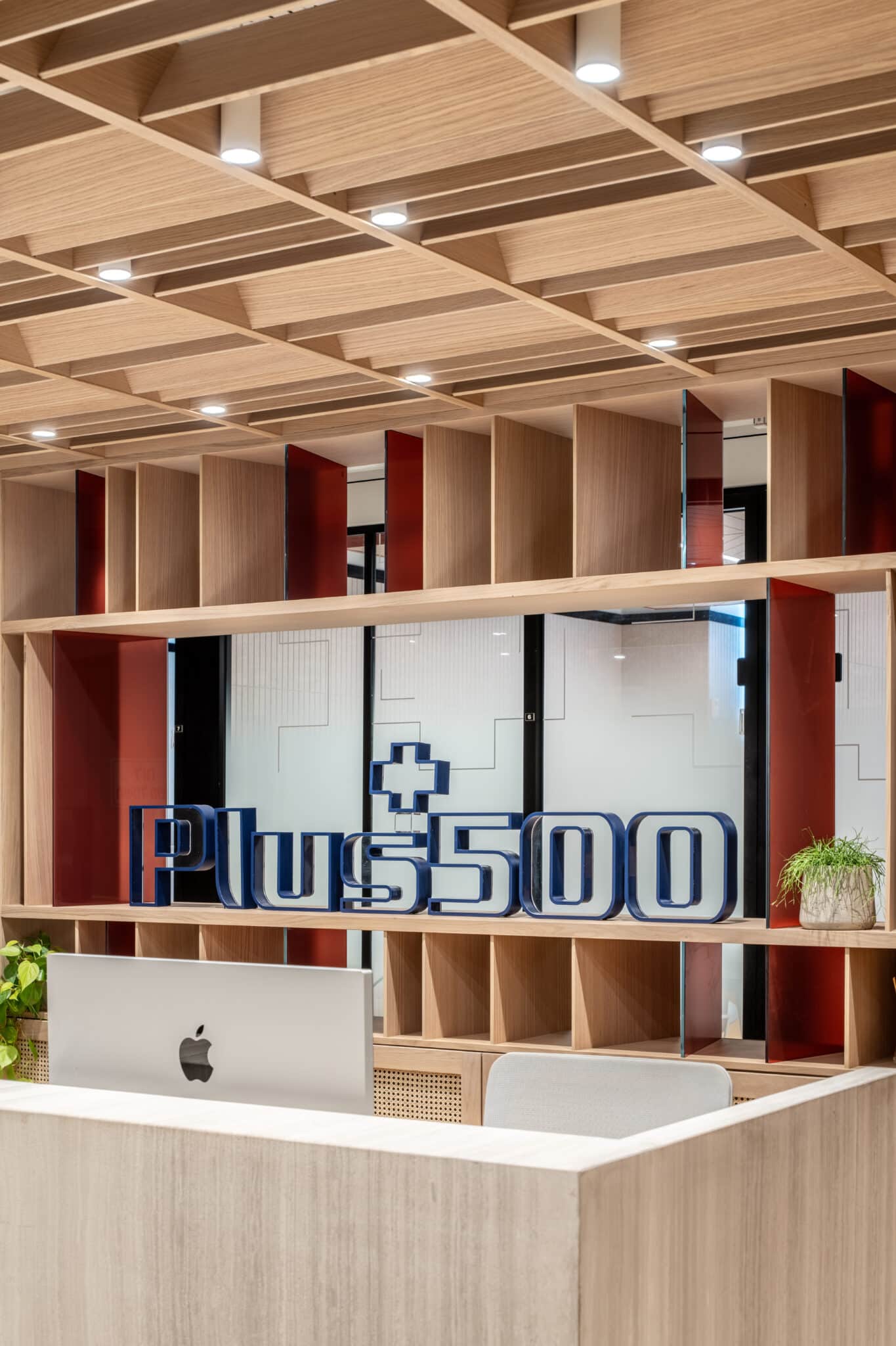 Blue 3D logo letters set in a wood shelving unit above reception