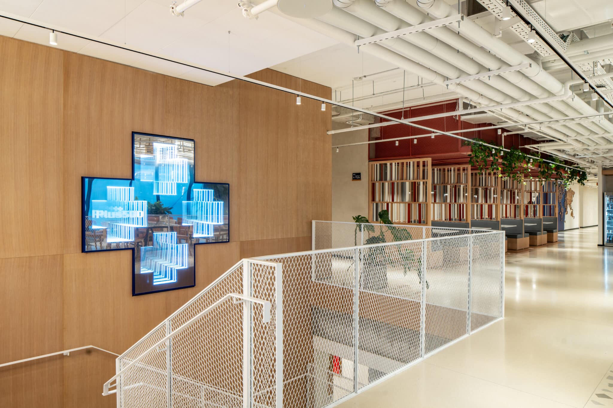 Cross shaped display screen on a wood wall above the stairs