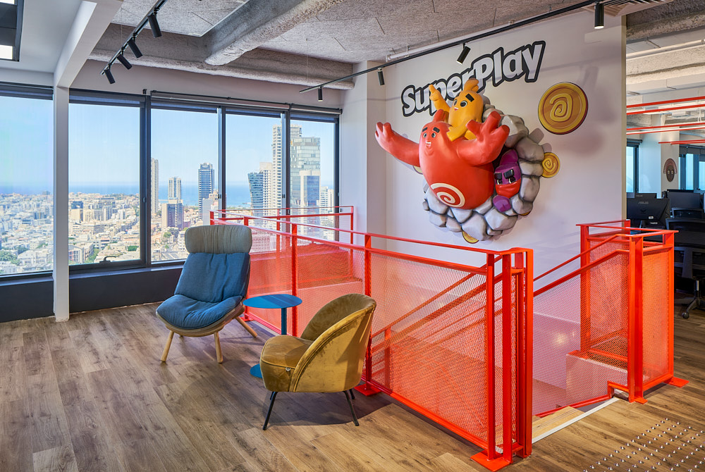 Red game character sculpture mounted under the SuperPlay wordmark