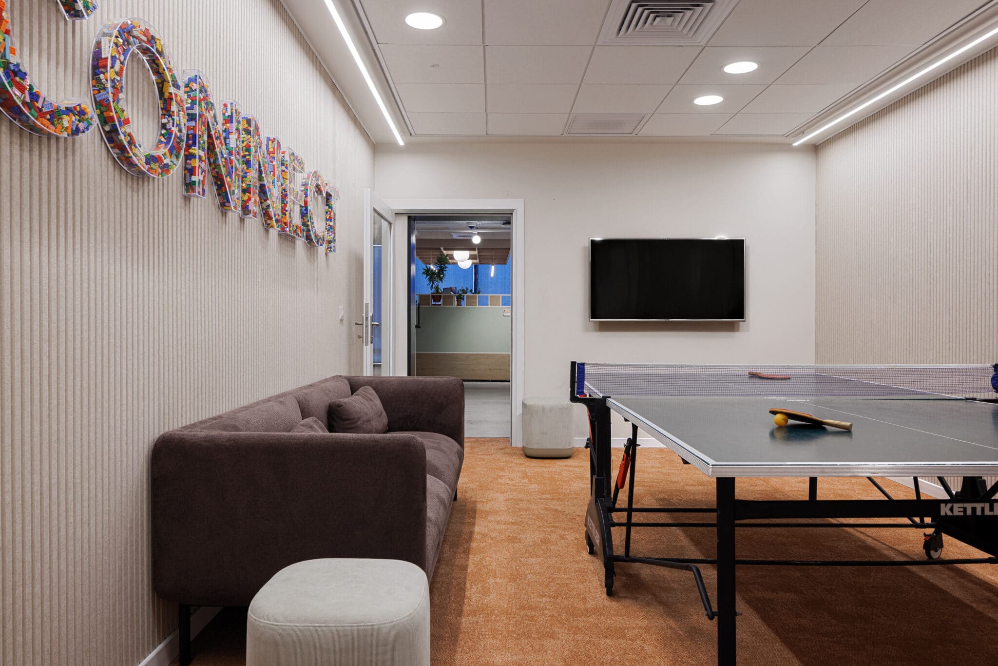 CONNECT 3D letters filled with colour above a games room sofa