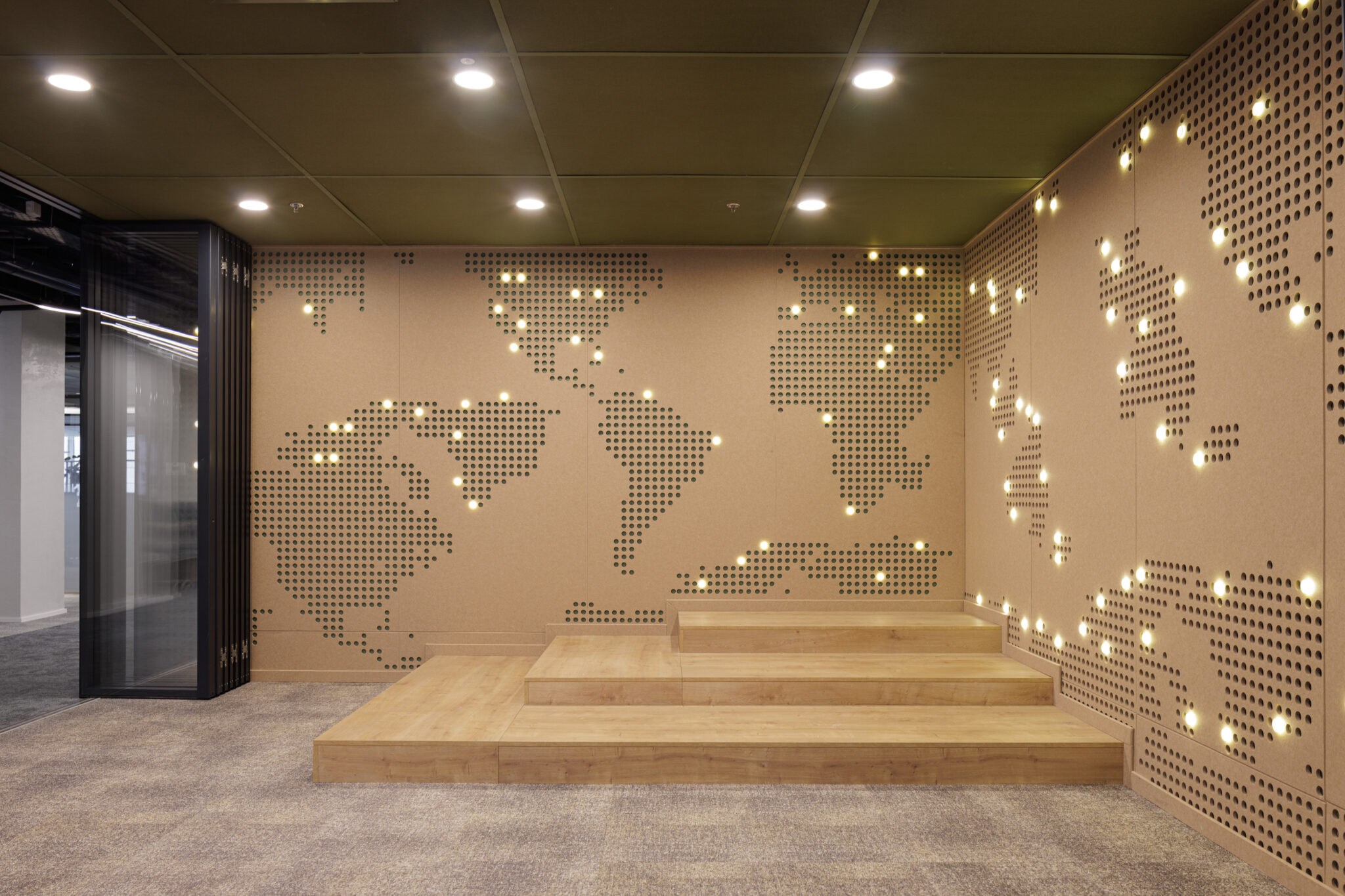 Perforated world map on acoustic wall panels with lit points