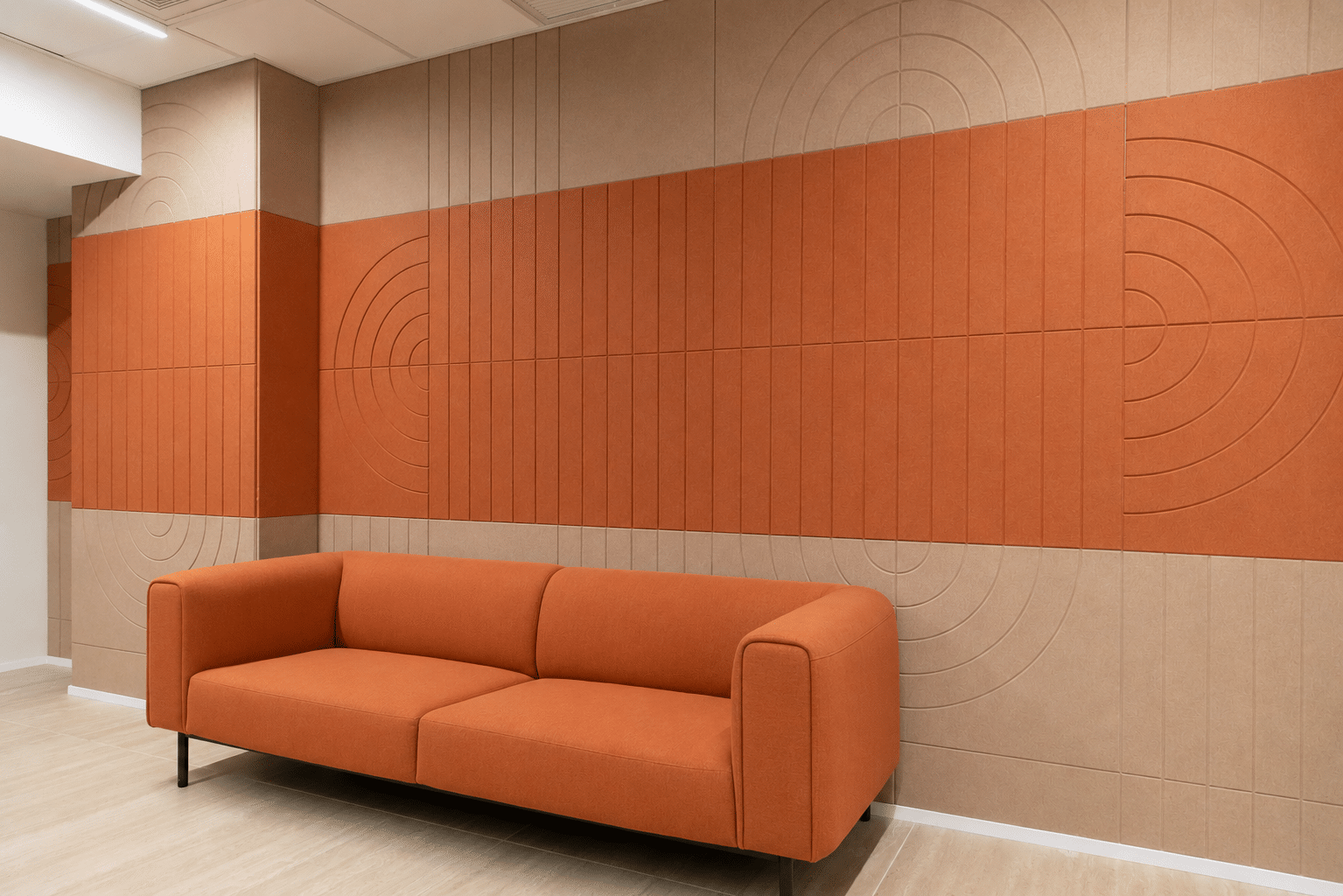 Acoustic wall panels in orange and beige with routed circle patterns