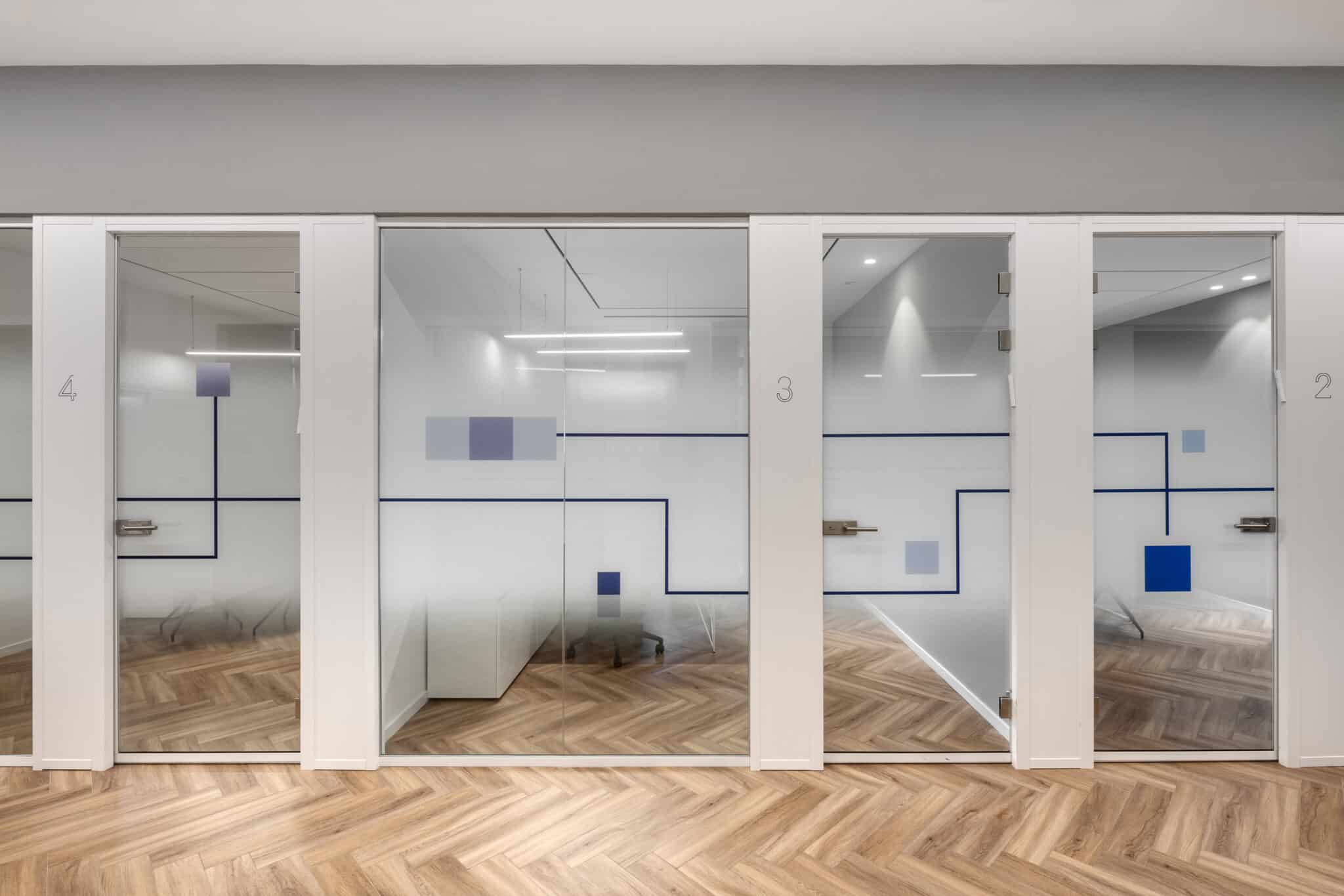 Room numbers and blue line graphics on frosted glass office fronts