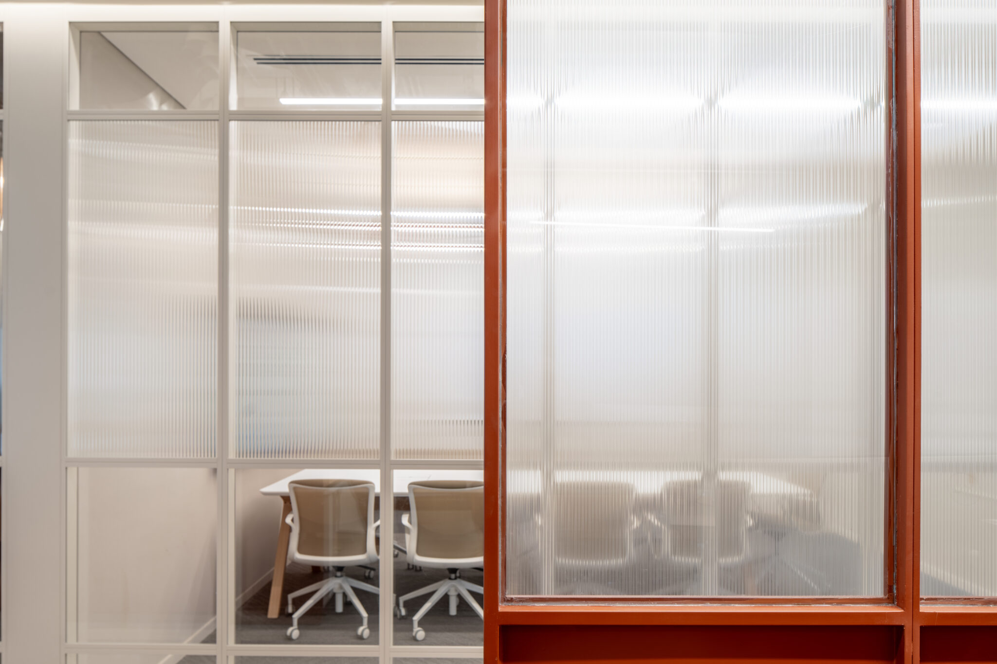 Reeded fluted glass panels framed in white and orange steel