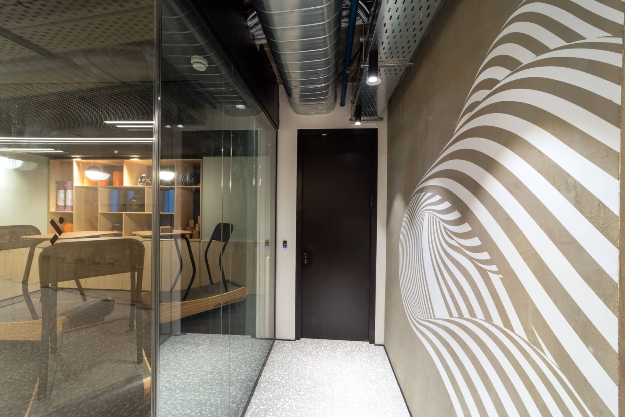 Swirling striped wall graphic beside a glass meeting room