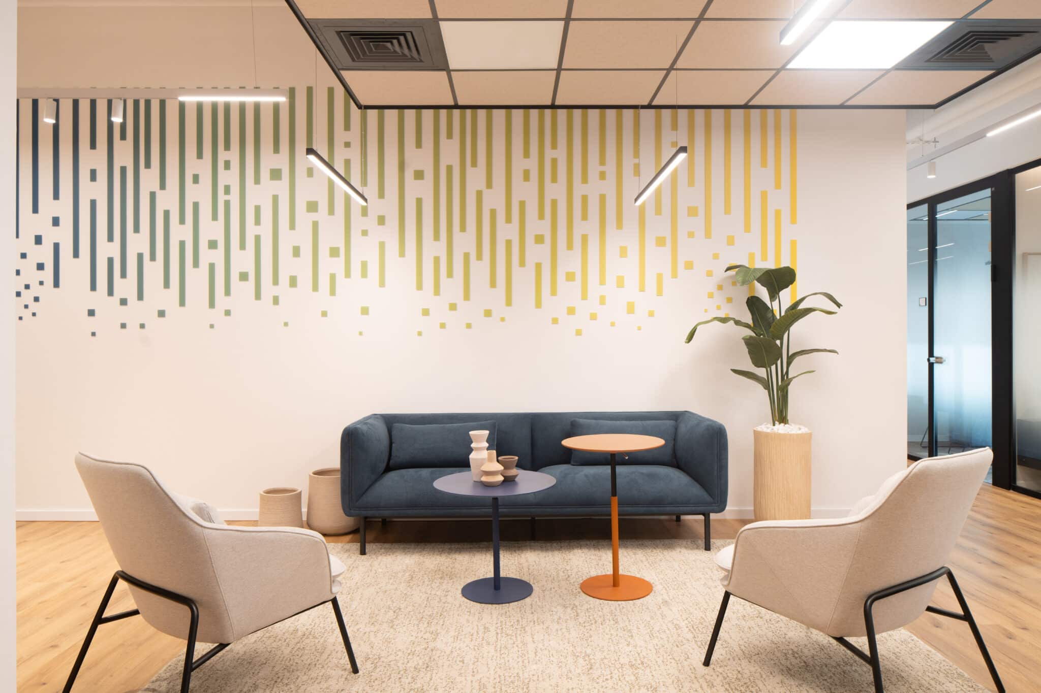 Gradient stripe wall graphic above a lounge seating area