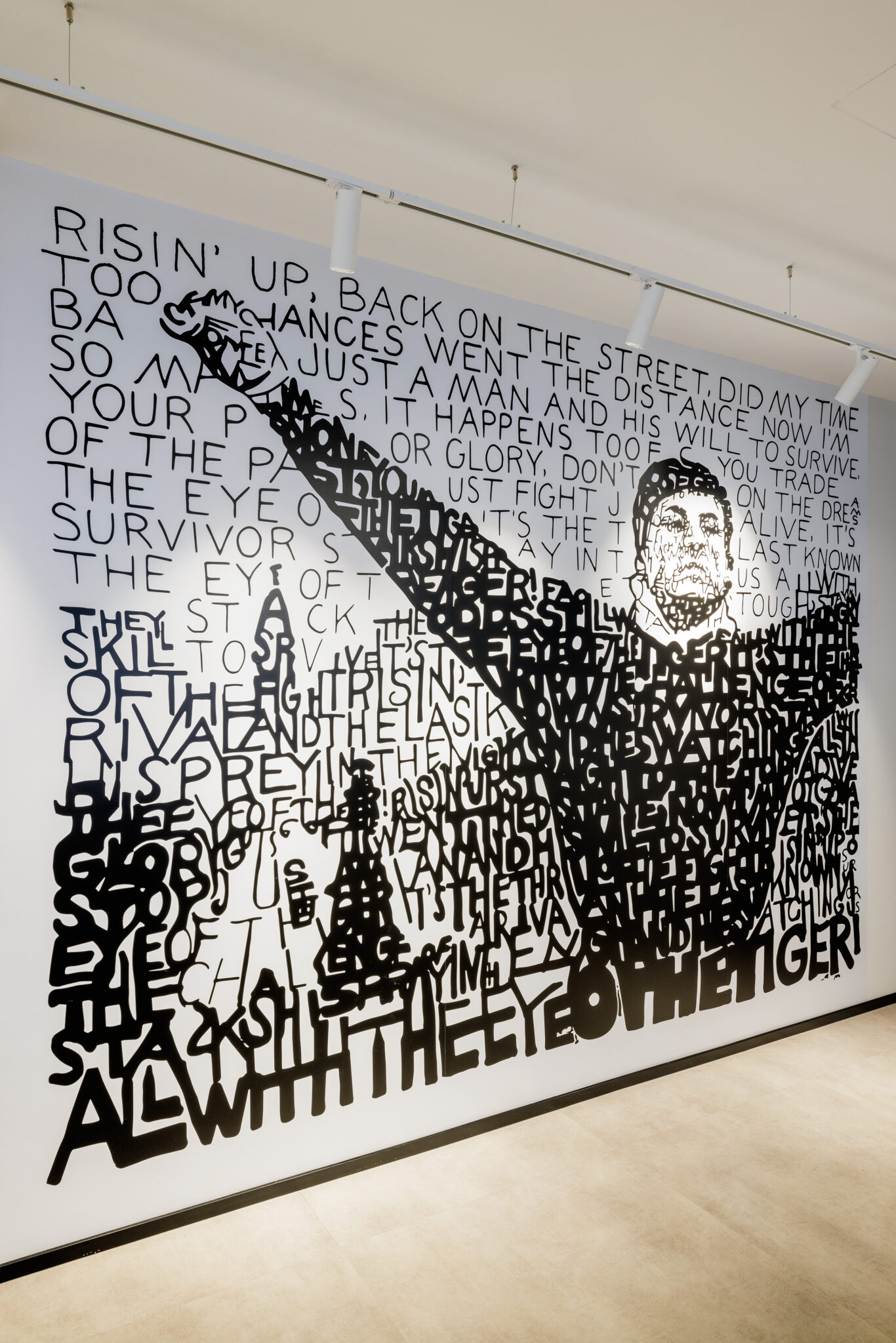Large typographic wall graphic of lyrics forming a boxer figure