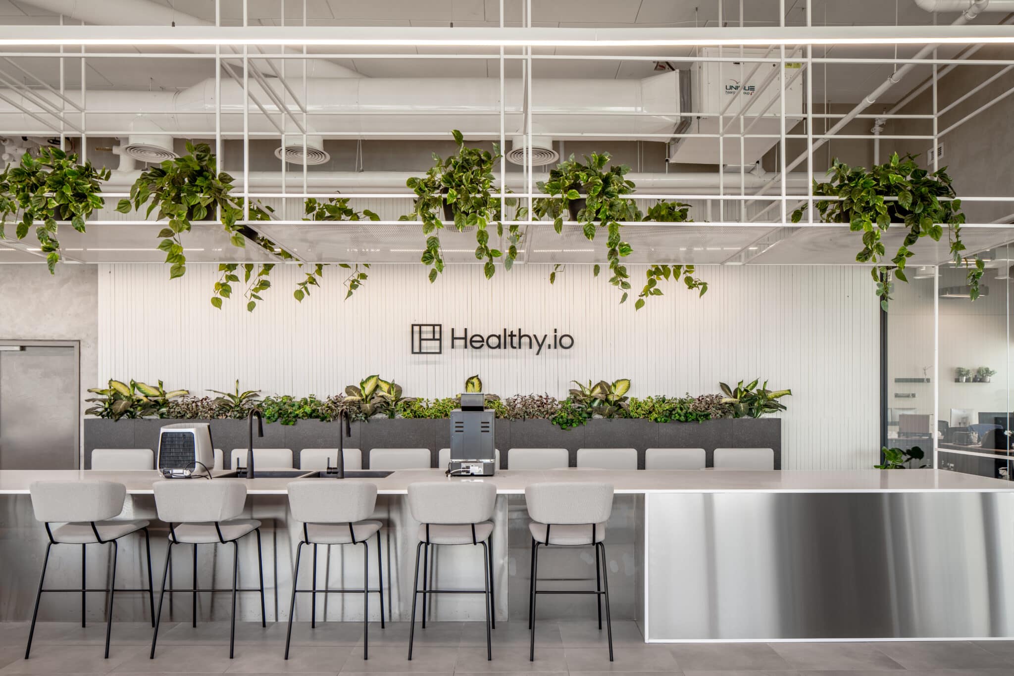Healthy.io logo on a fluted wall above a planted counter