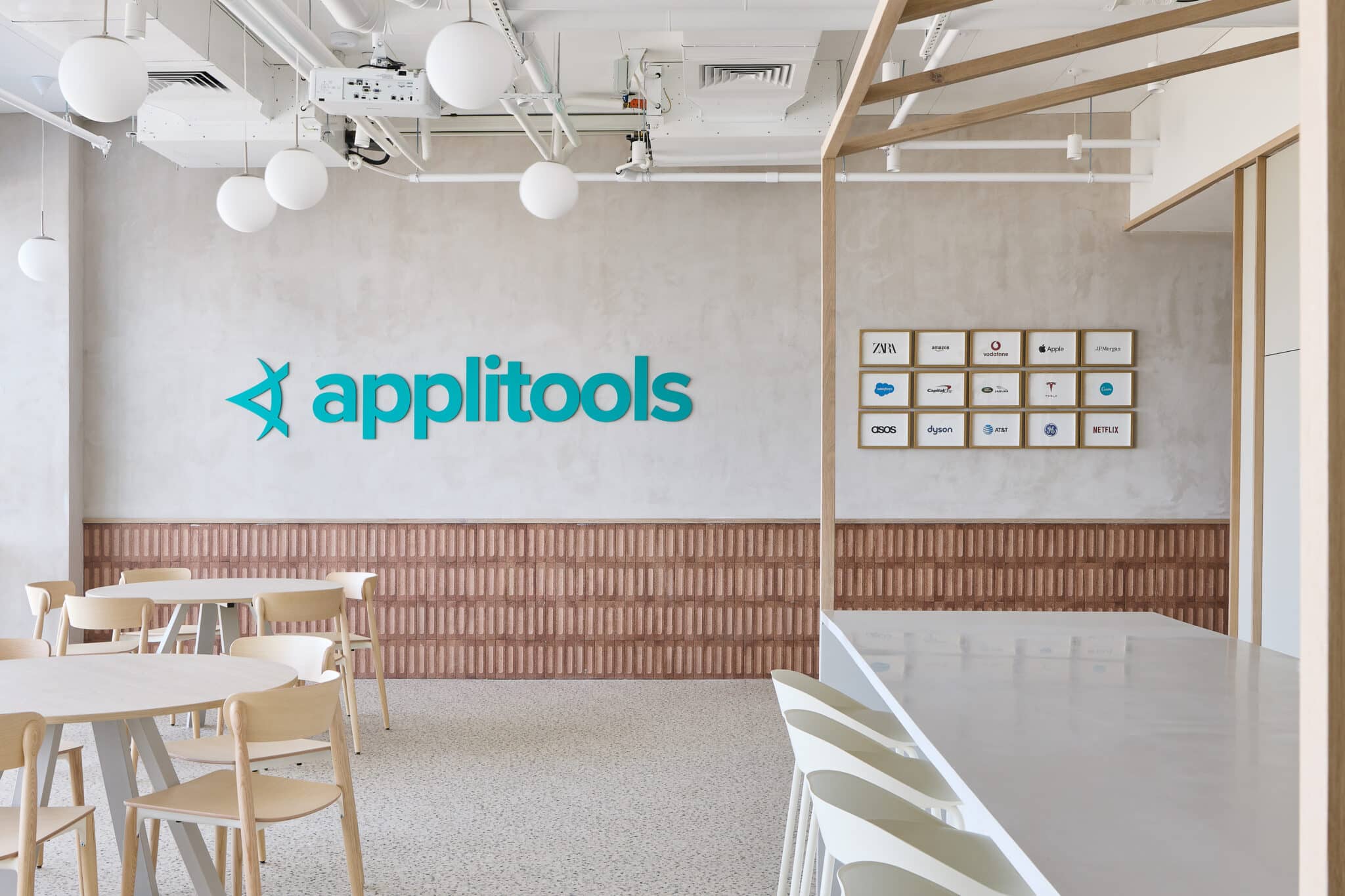 applitools 3D logo on a concrete wall above brick cladding