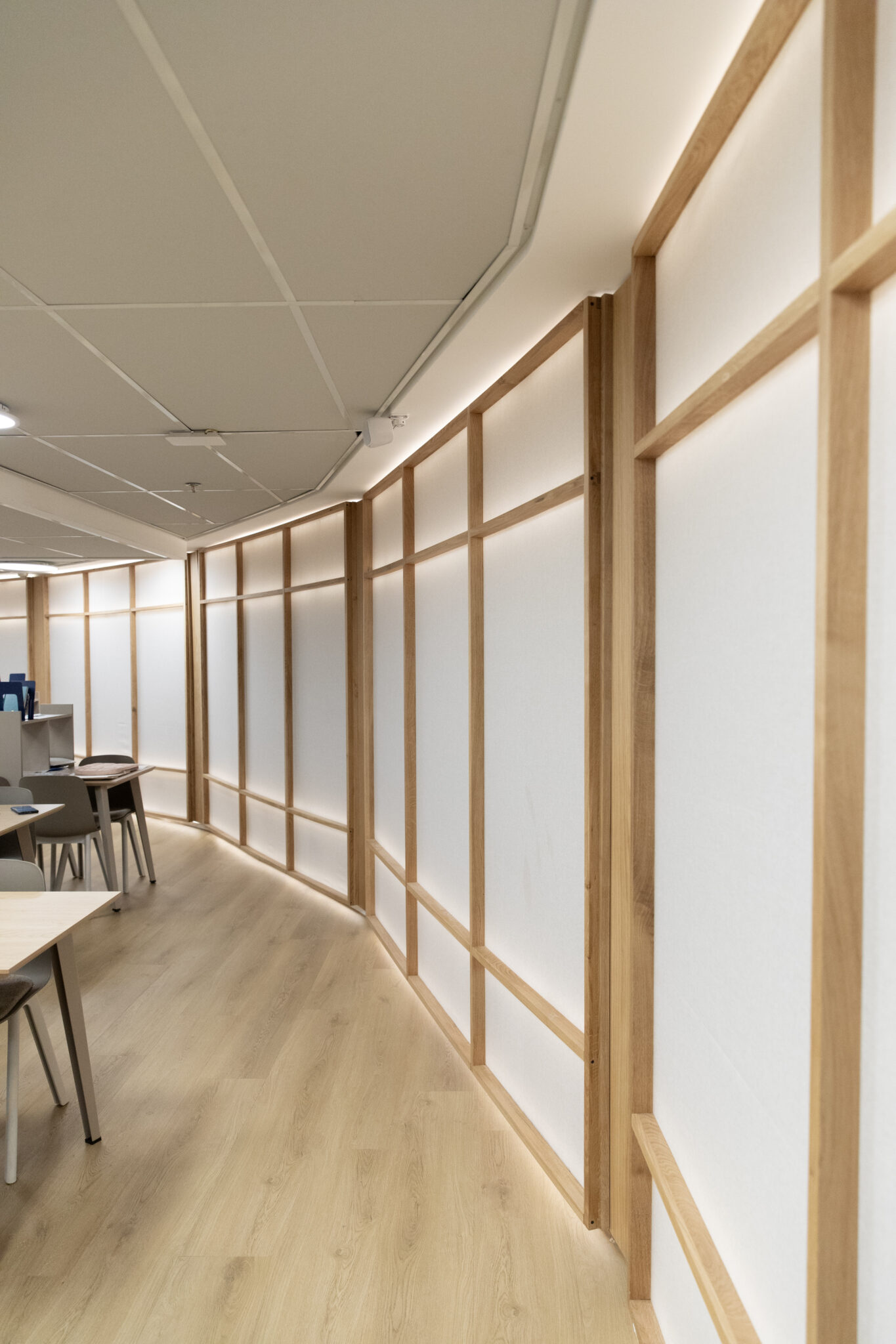 Wood framed backlit panels running along a study hall wall