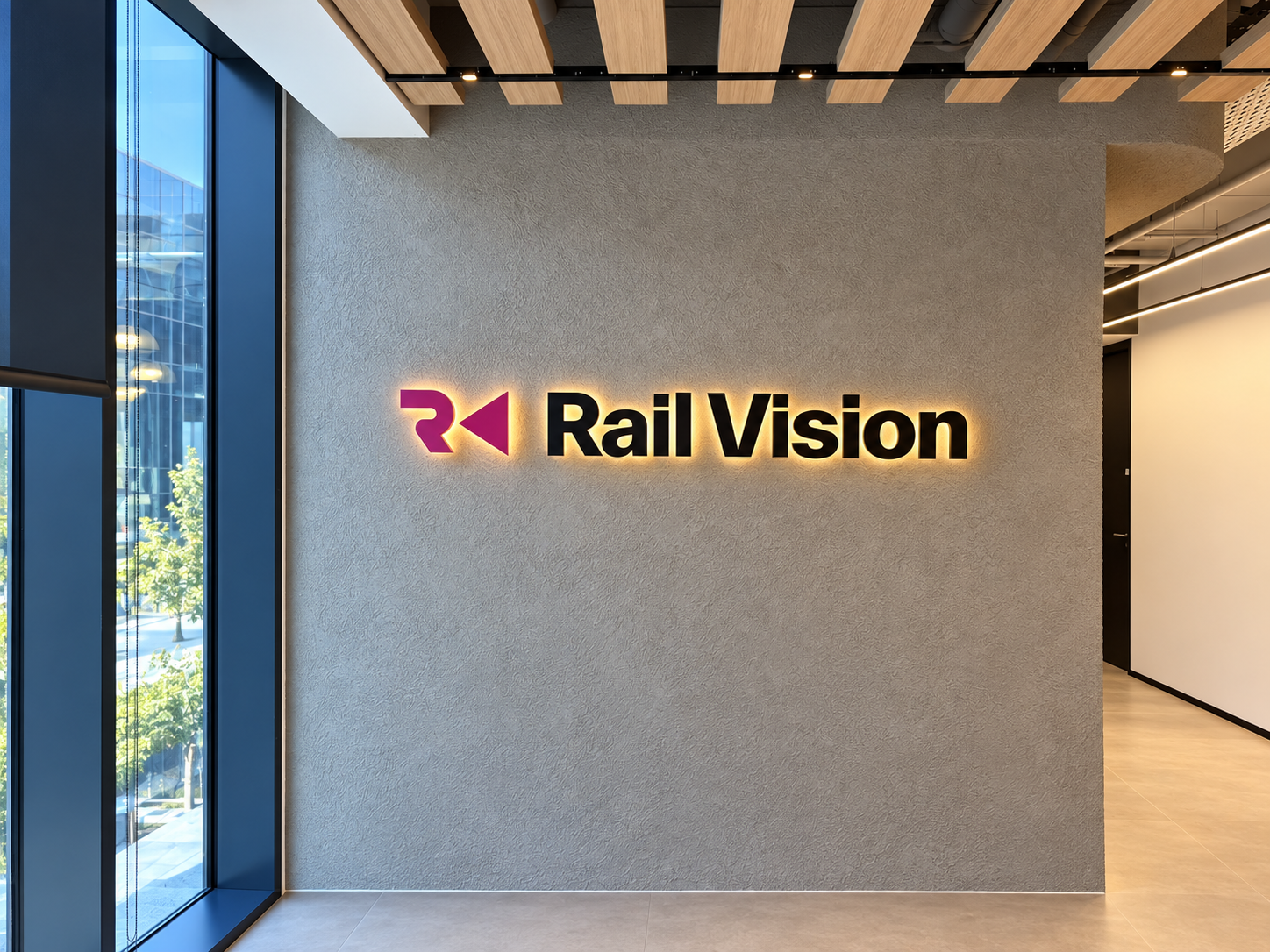 Rail Vision lit logo on a grey wall