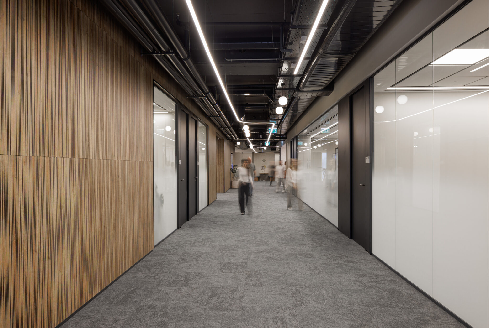 Wood slat cladding facing frosted glass partitions in a corridor