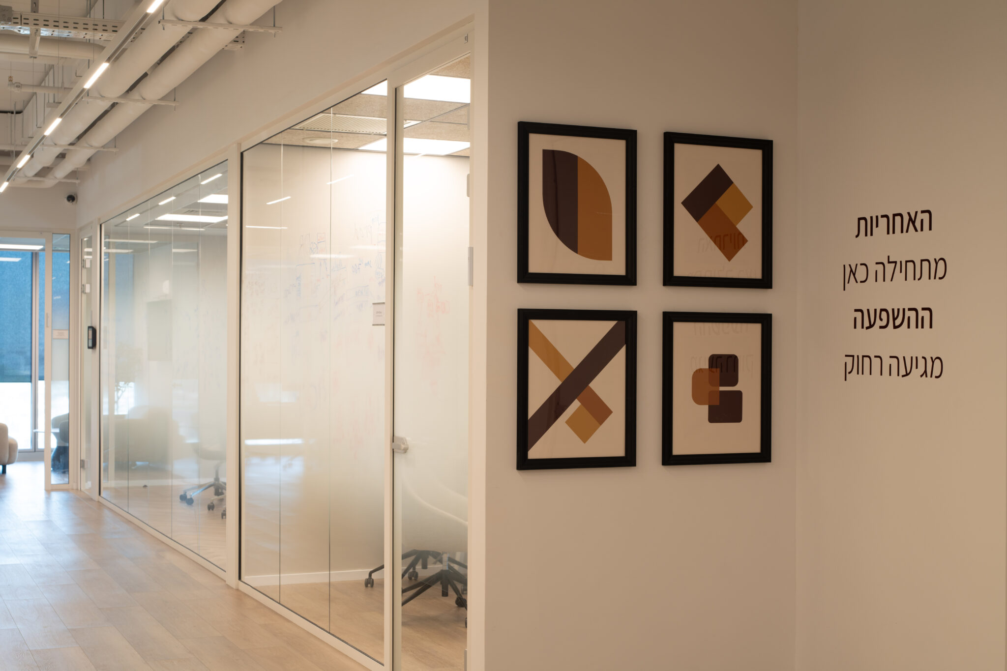 Framed geometric wood artworks beside Hebrew wall lettering