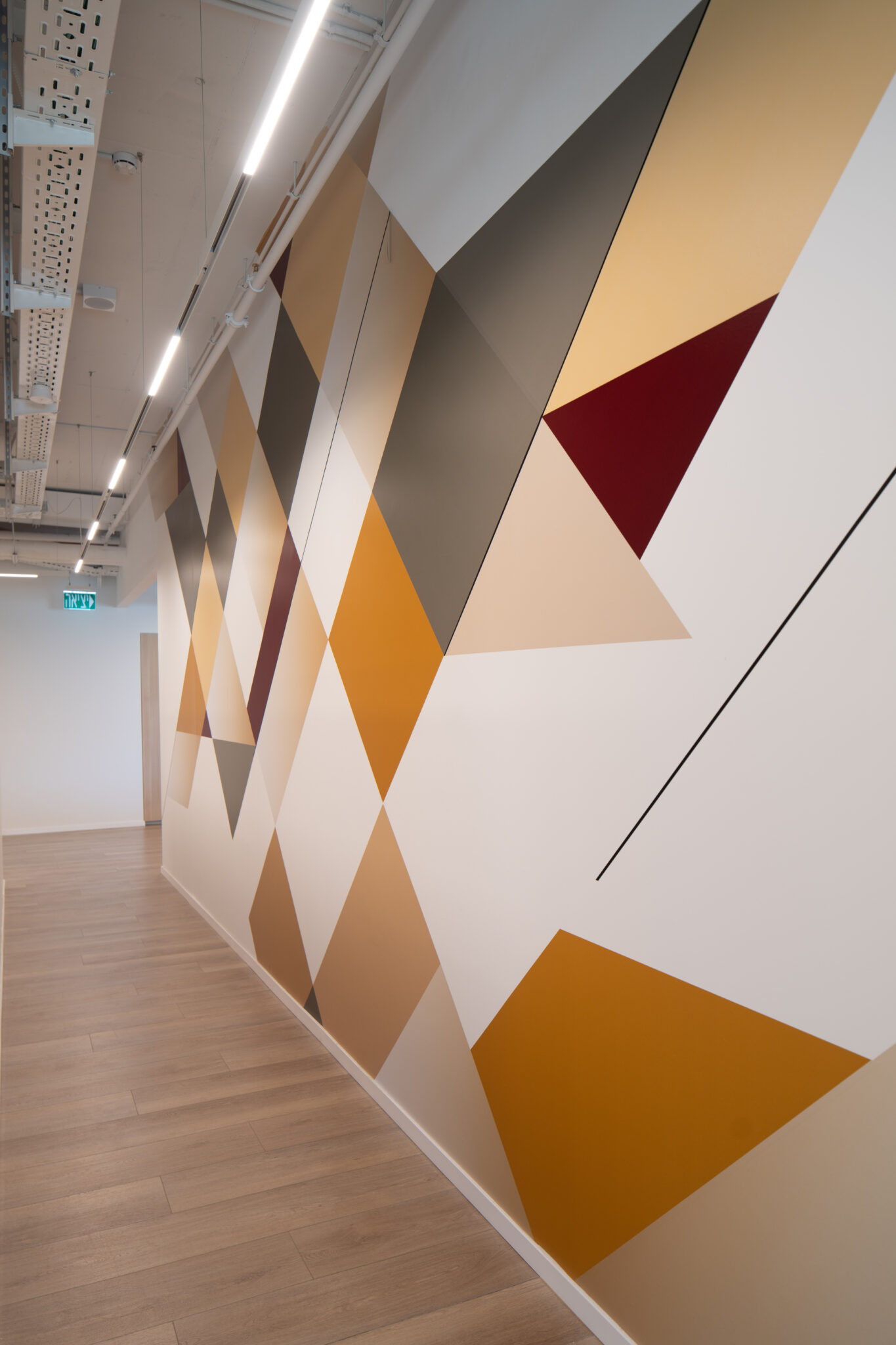 Corridor wall graphic of large orange, grey and red triangles