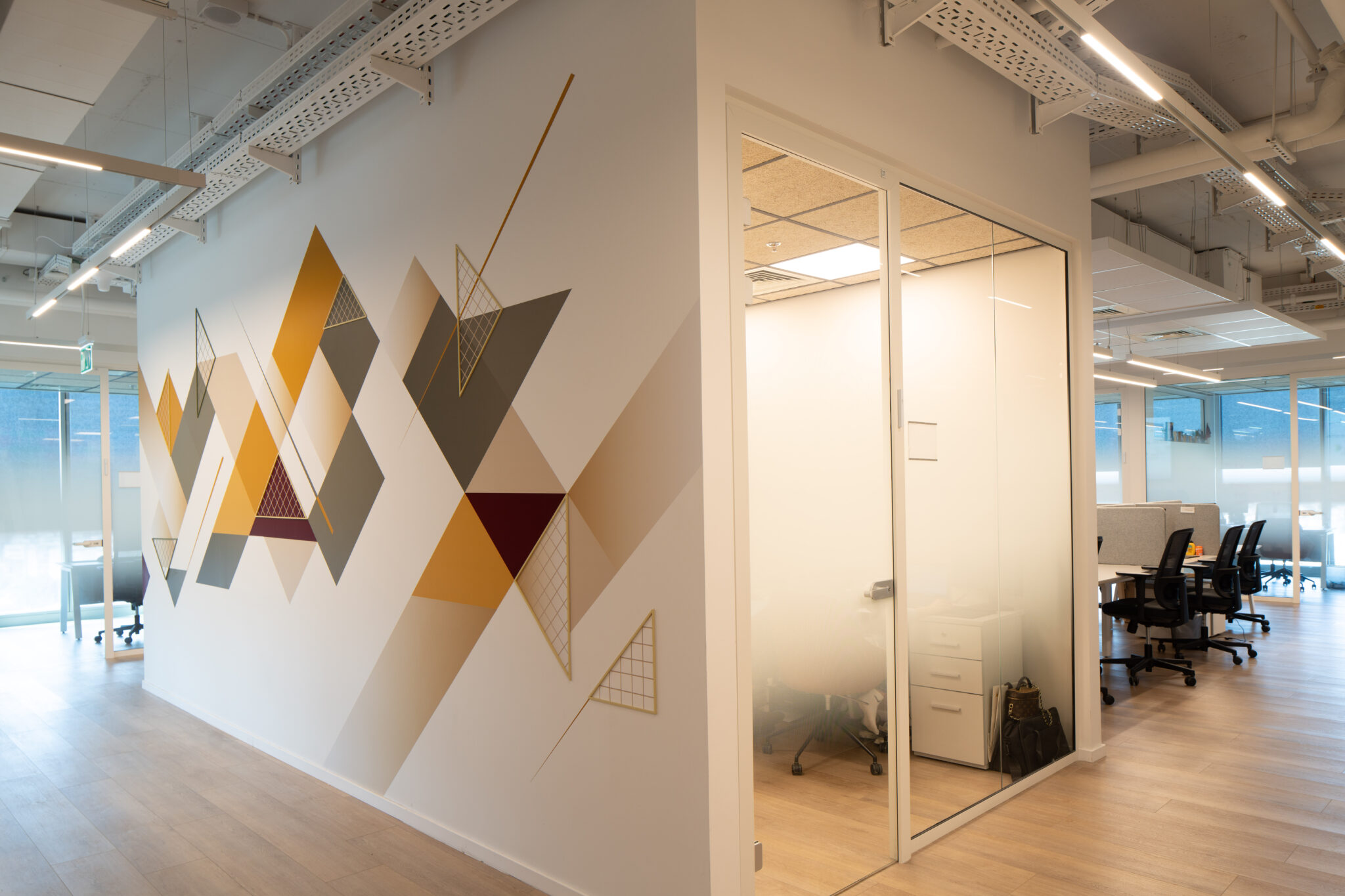 Geometric triangle wall graphic beside a glass office