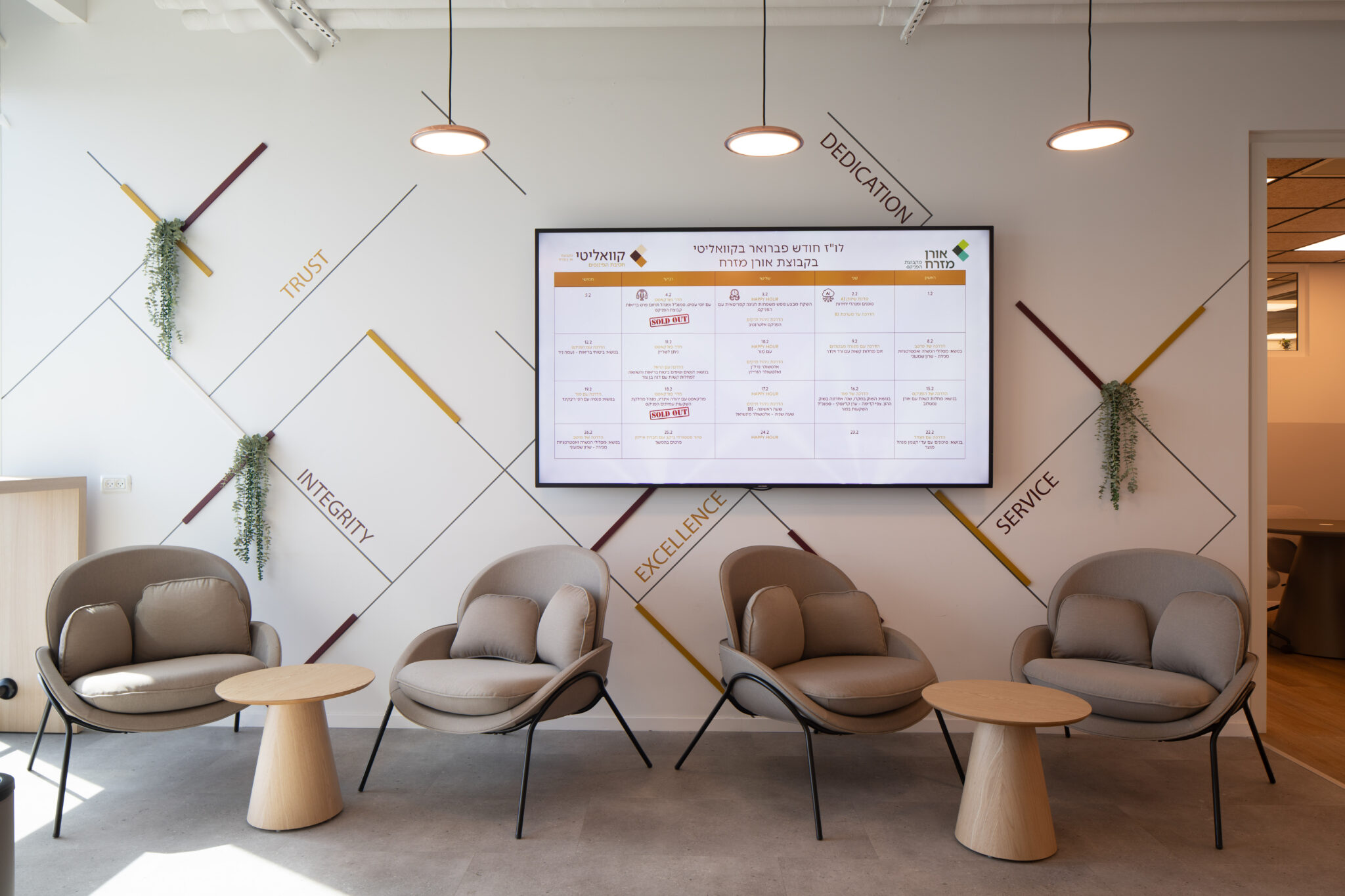Waiting area with lounge chairs and line art wall with value words