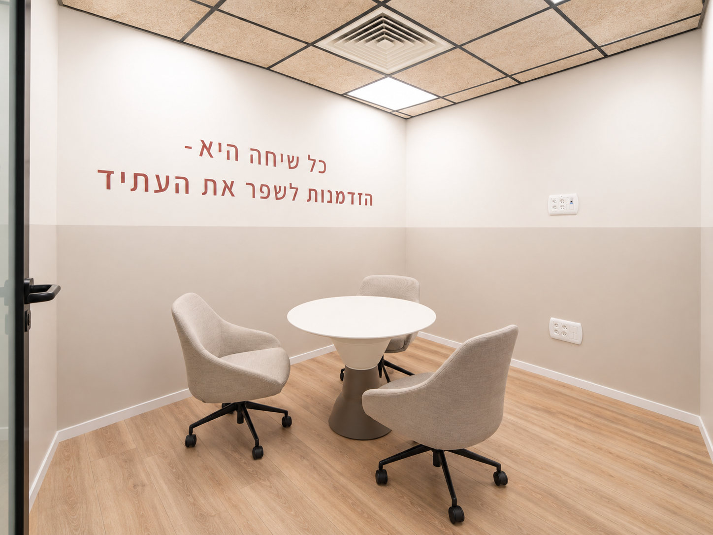 Small meeting room with a Hebrew quote on the wall